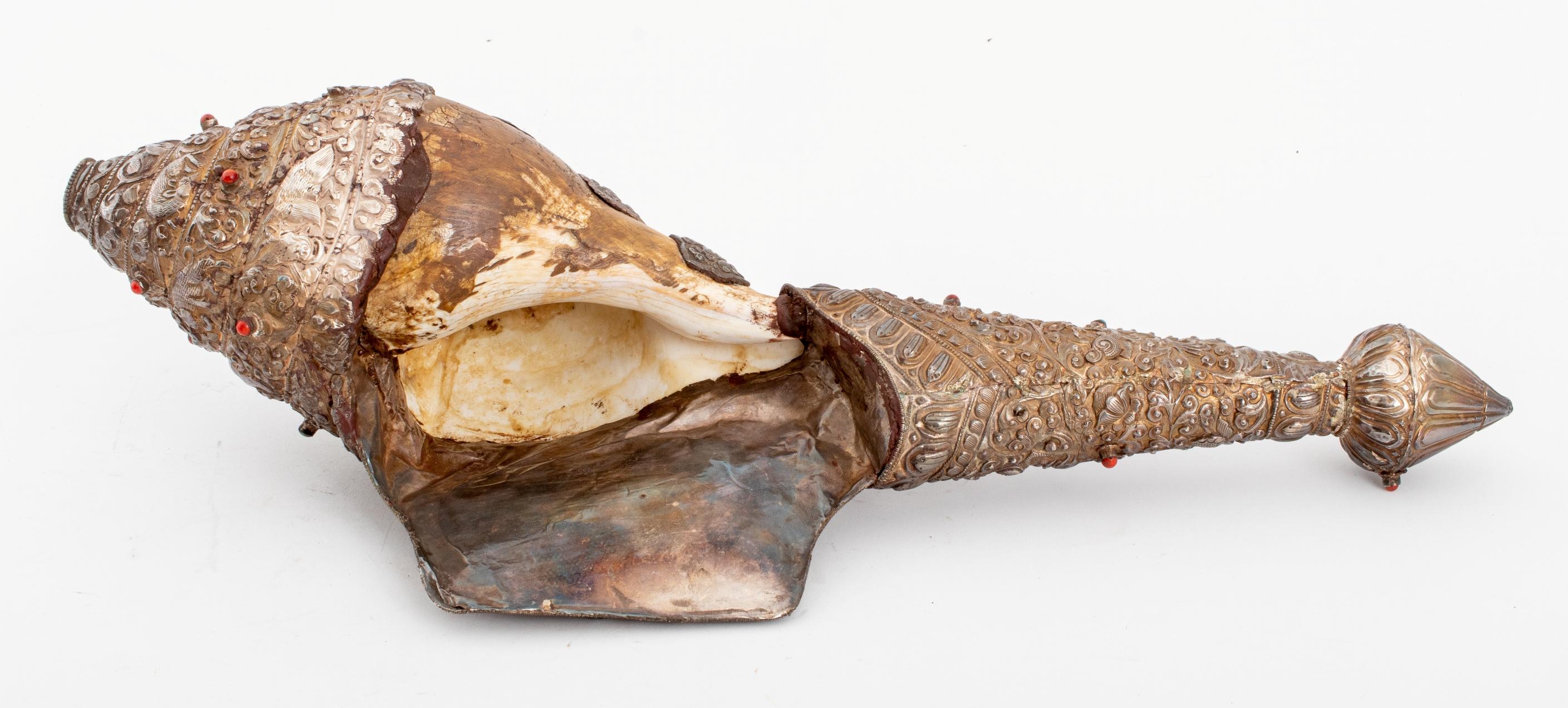 Antique Tibetan silver covered Buddhist conch shell horn with incised and repousse decoration comprising animals including dragon, birds, rabbit, and lion, upon a scrolling foliate ground, as well as the eight auspicious emblems of Buddhism, further