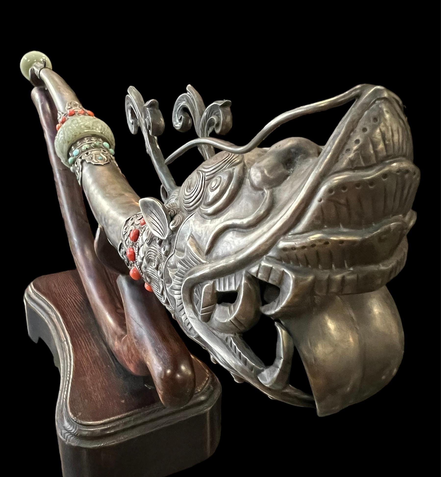 Rare hand beaten Tibetan tantric ritual instrument.
It is Jade and Silver (low grade) with insert of coral & turquoise. It comes with an antique custom-made wooden stand.

It is handcrafted by master craftsman for high tantric