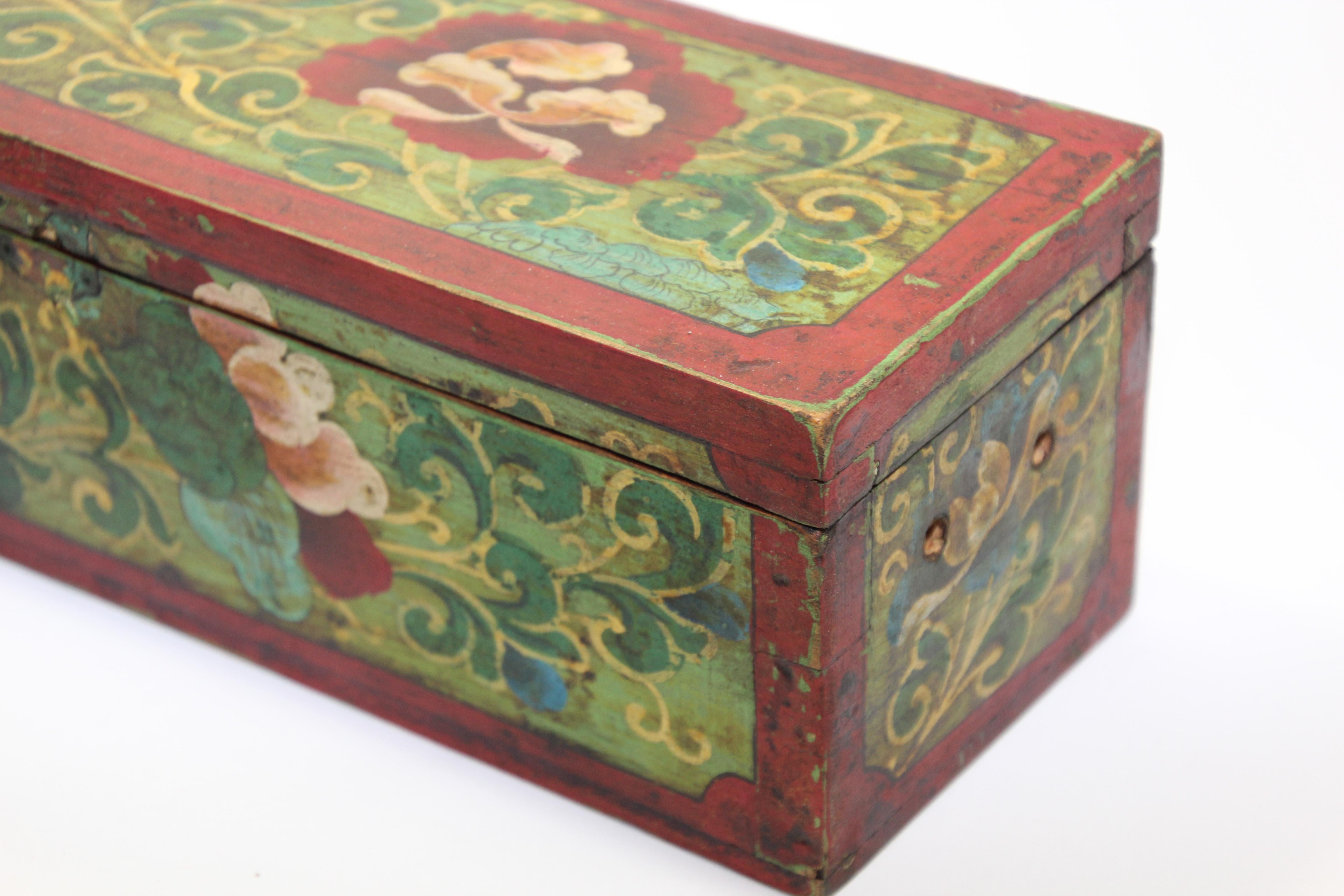 Hand painted Tibetan decorative box.
Hand painted wood in an rectangular shape with hinged lid and decorated with vibrant floral designs on red.
A vintage Tibetan wood box, exquisitely painted with flowers in green and yellow on a dark burgundy