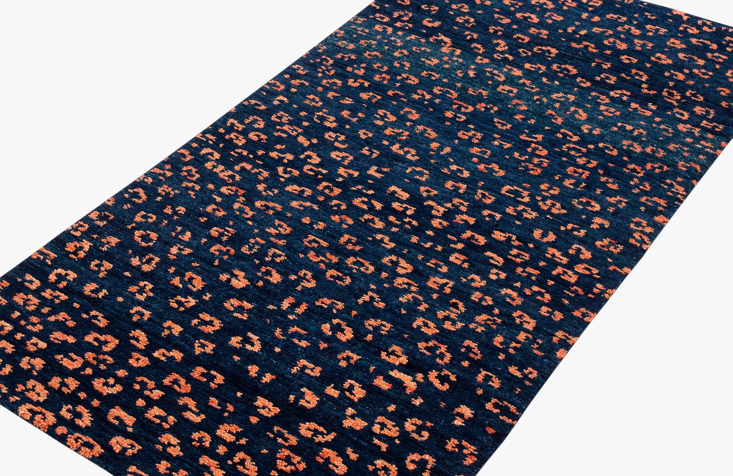A deep indigo contrasts against the orange spots in this leopard print design. Handwoven in handspun Himalayan wool, Joseph Carini was inspired by the markings on one of the most majestic and elusive wild creatures, in a versatile 3' x 6' size, it