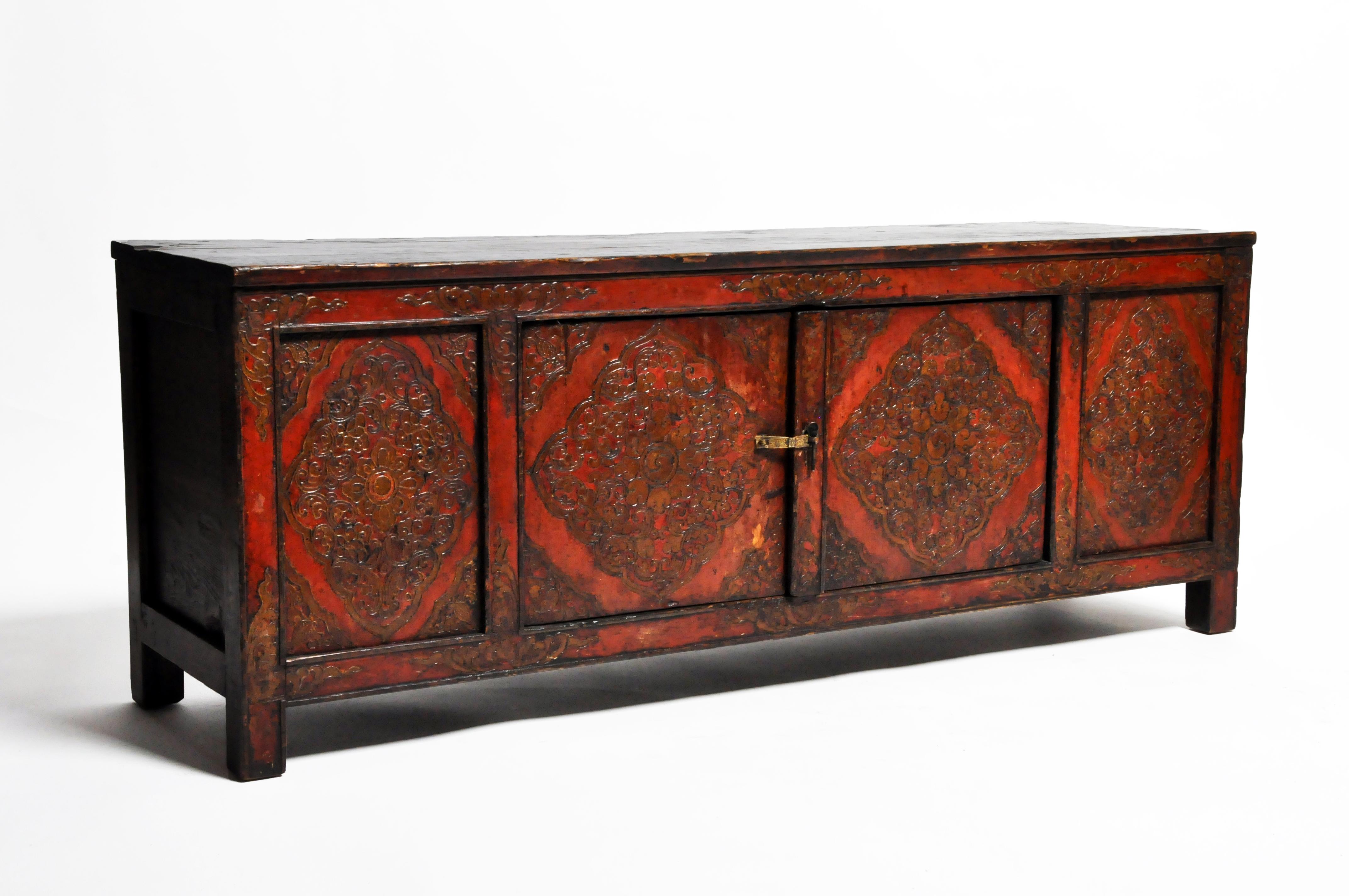 This low cabinet is from Tibet and made from wood and lacquer. The piece features a beautifully aged patina and a pair of doors for storage space.