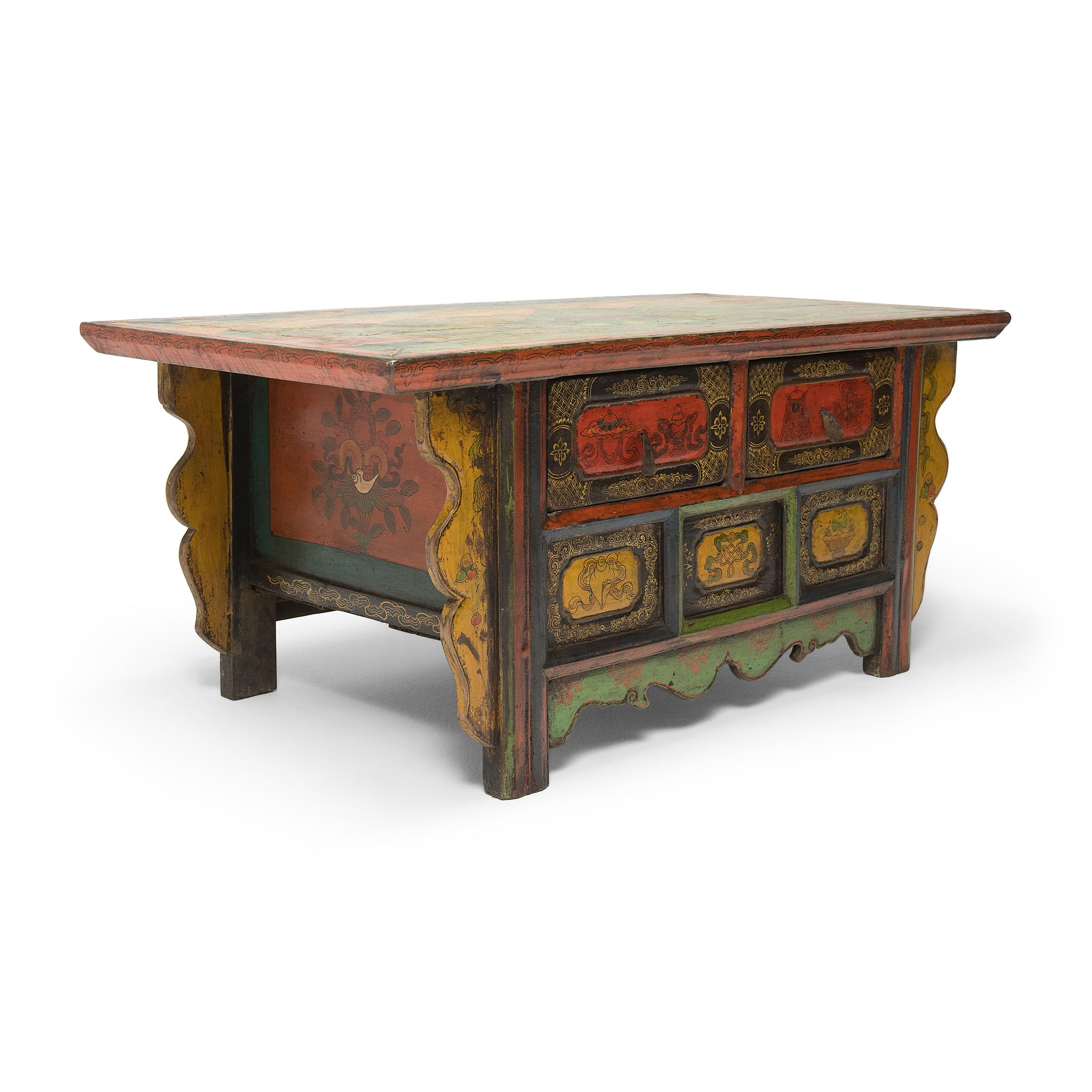This low two-drawer chest is a 19th-century coffer from northern China or Mongolia and was repainted with bright colors in the early 20th century in the style of Tibetan painted furniture. The top surface has been painted with verdant mountainous