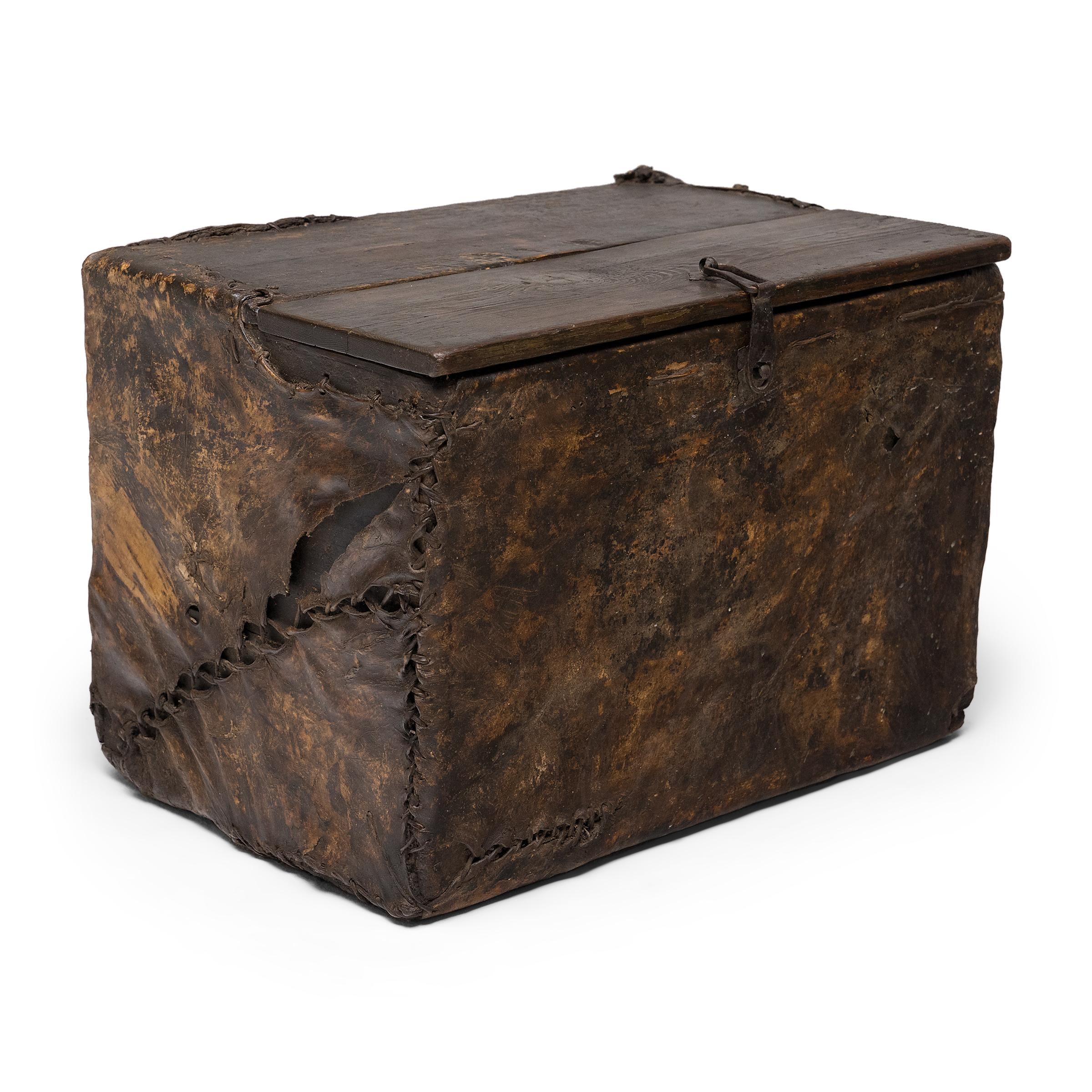 This fantastic antique trunk from the mid-19th century once belonged to a nomadic traveler of the Tibetan Plateau or the Himalayas. One of the most unique items in our collection, the wooden chest is encased in a lacquered hide sheath that insulated