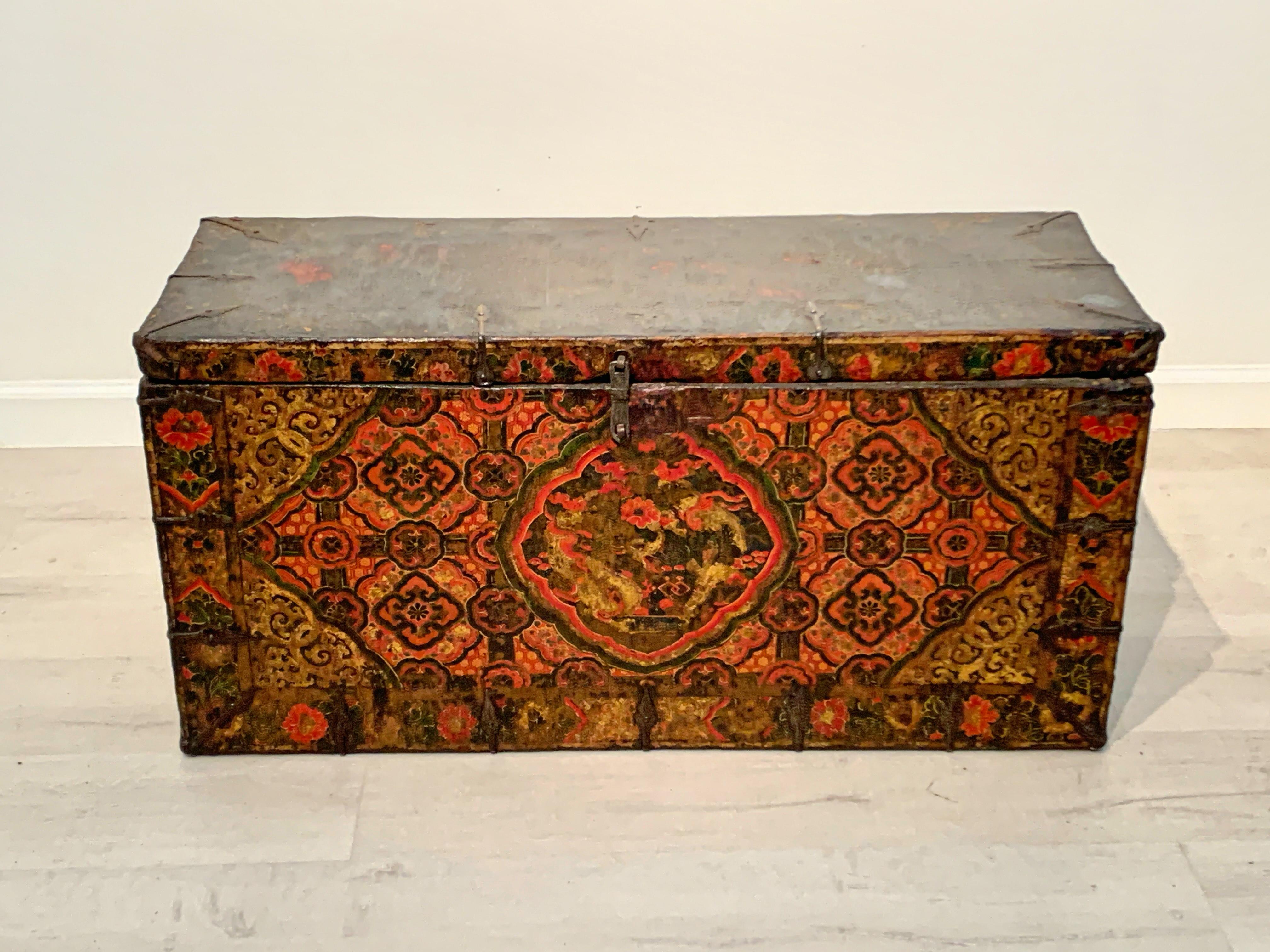 A vibrant and powerful Tibetan polychrome painted and gilt storage chest with a dragon and 'kati rimo' (brocade) design, 17th-18th century, Tibet.

The medium sized Tibetan storage trunk of simple wood construction, with a simple metal latch and