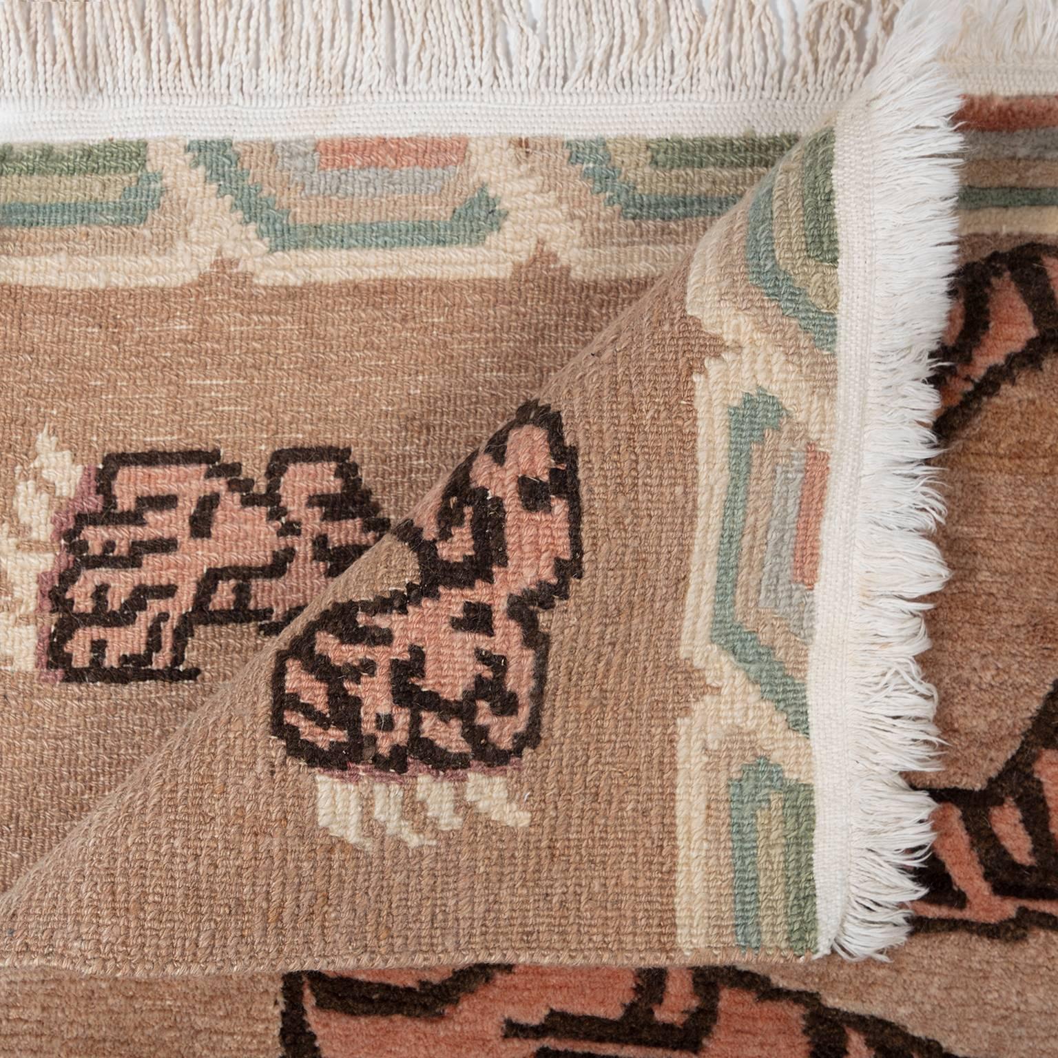 In a palette of pinks, creams and pale greens, this vintage Khaden carpet may once have been used by a Buddhist lama. In Tibet, woven rugs depicting stylized tiger skins are used for meditation. Symbolic of the monk’s control over earthly desire,
