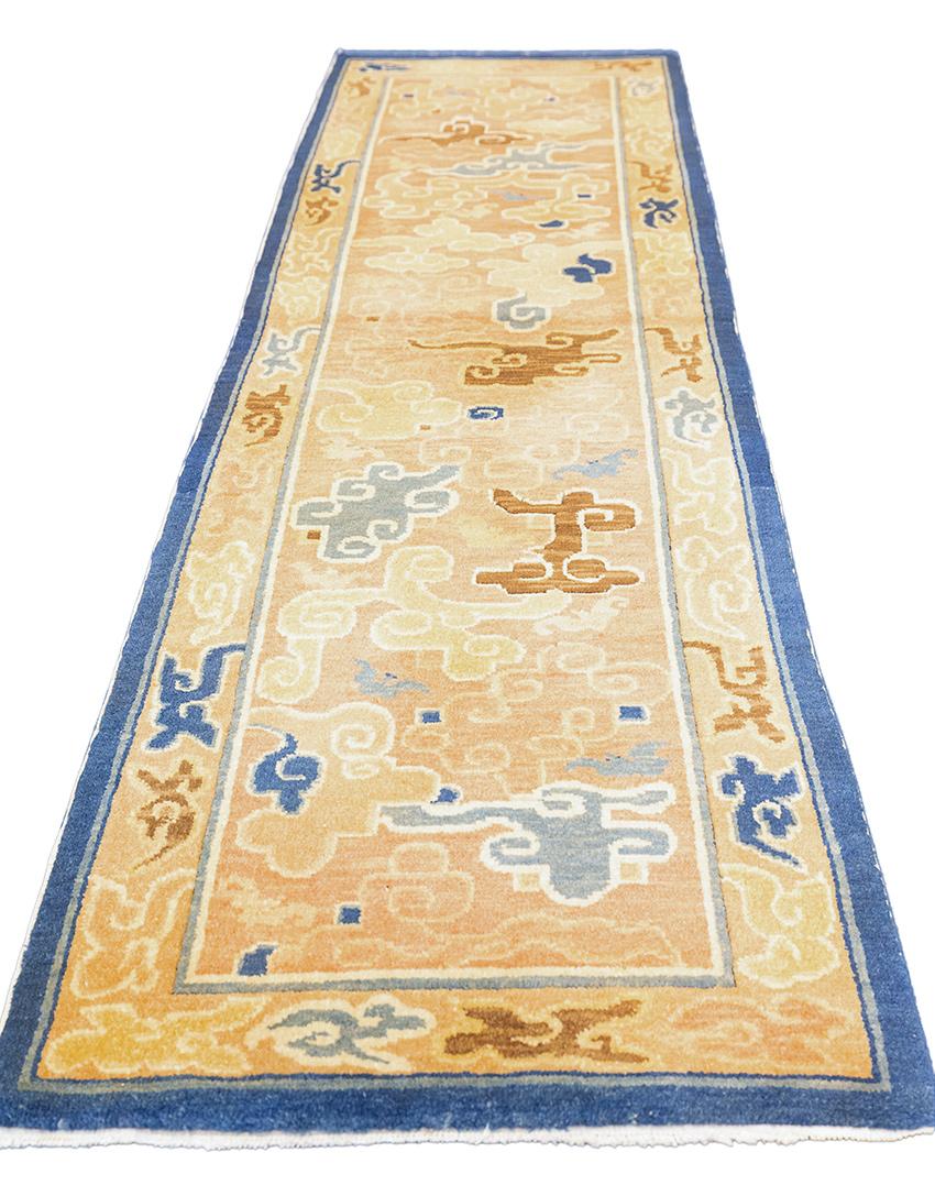 A stunning antique Tibetan rug featuring a classic cloud band motif. Crafted with a harmonious color palette of beige, brown, grey, and subtle hints of beige, this rug exudes elegance and timeless charm. The intricate cloud band design adorns the