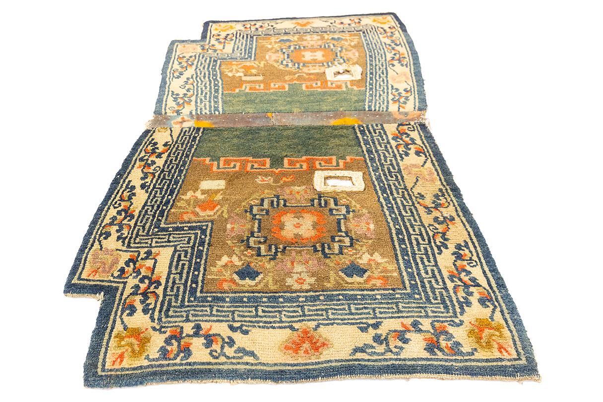 This antique Tibetan rug, measuring 118 × 70 cm (3' 10
