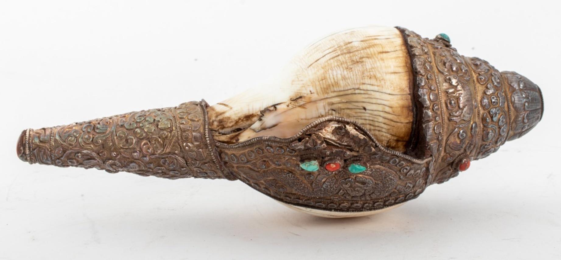 Antique Tibetan silver covered conch shell Horn with incised and repousse decoration comprising animals on a scrolling foliate ground, the mouthpiece with stylized lotus flower design, mounted with turquoise and coral cabochons, circa nineteenth