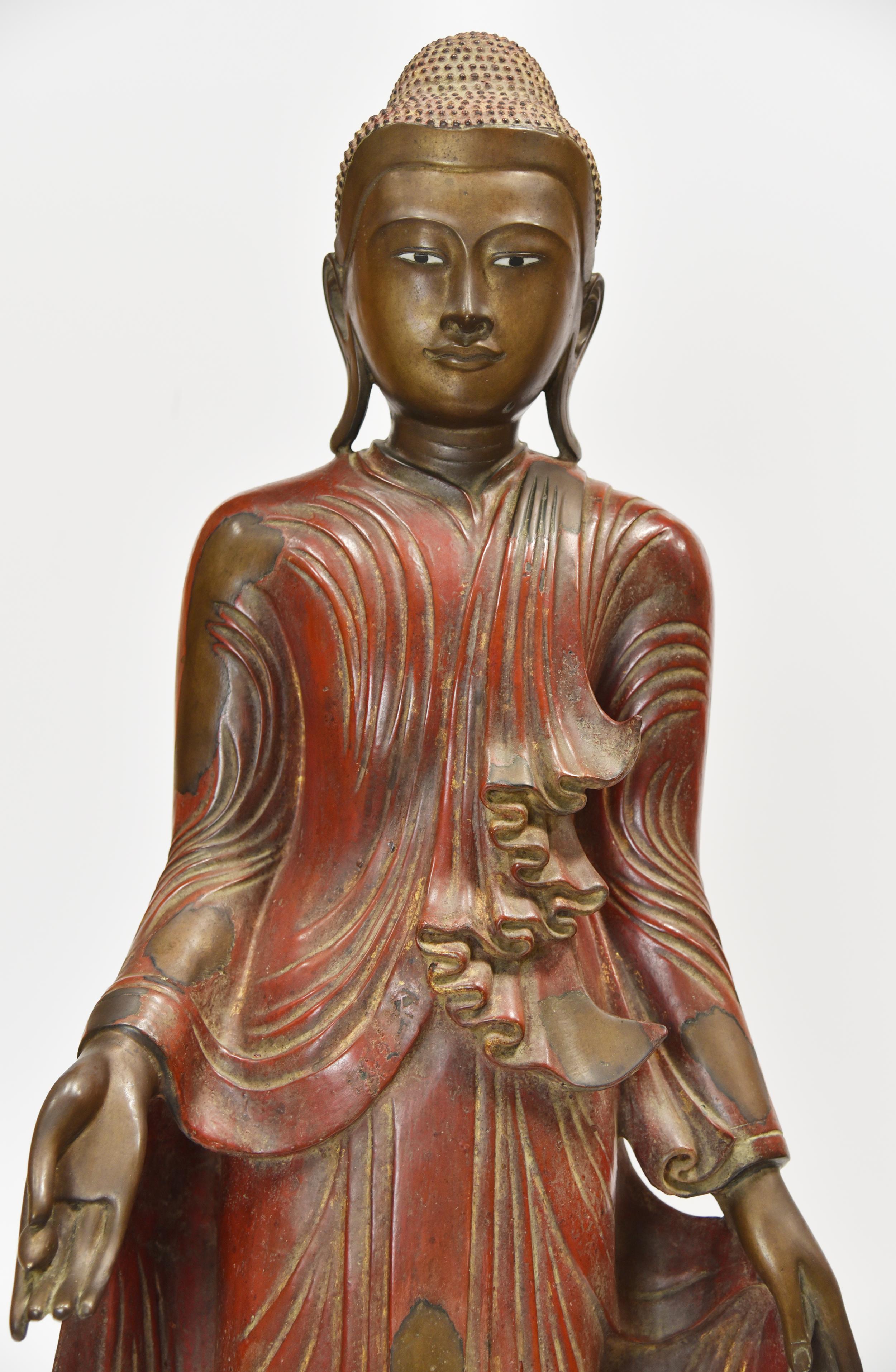 A two-part tall standing cast bronze Buddha figure with jewelled, gilt-inlaid base. Original red lacquer painting in this figure and fully robed design shows throughout this figure. Gorgeous intact expression in the face and body of this female
