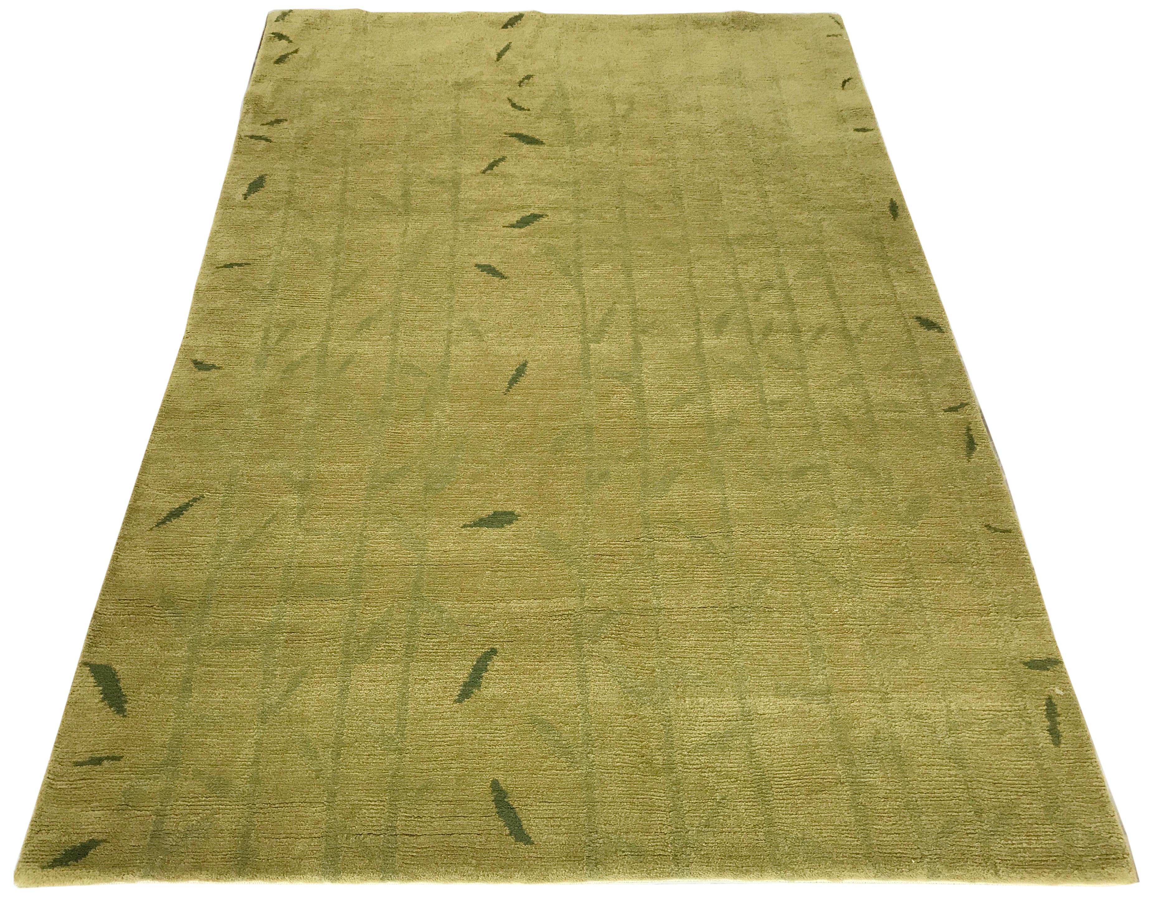 Bring the calming effect of nature indoors with this charming Tibetan-style rug. Subtle bamboo stalks and bold falling leaves create a botanical overlay on a warm golden wool and silk canvas. The soft low pile is both comforting underfoot and