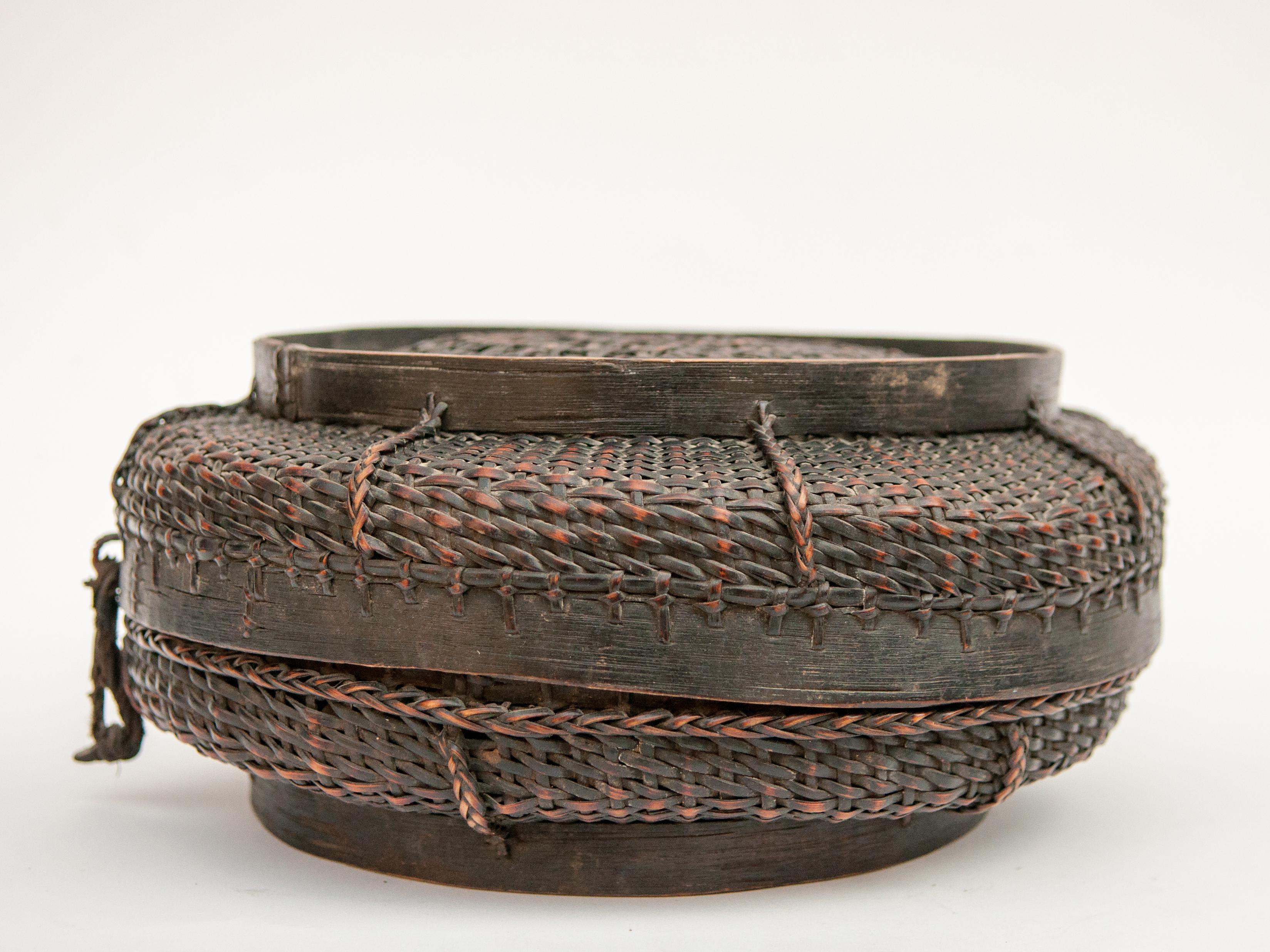 Tibetan style tribal food basket with lid from Tibet or Bhutan, mid-20th century.
This handsome bamboo basket has a wooden rim top and bottom, which can also function as base when the two halves are opened up to serve as trays. It is cleanly and