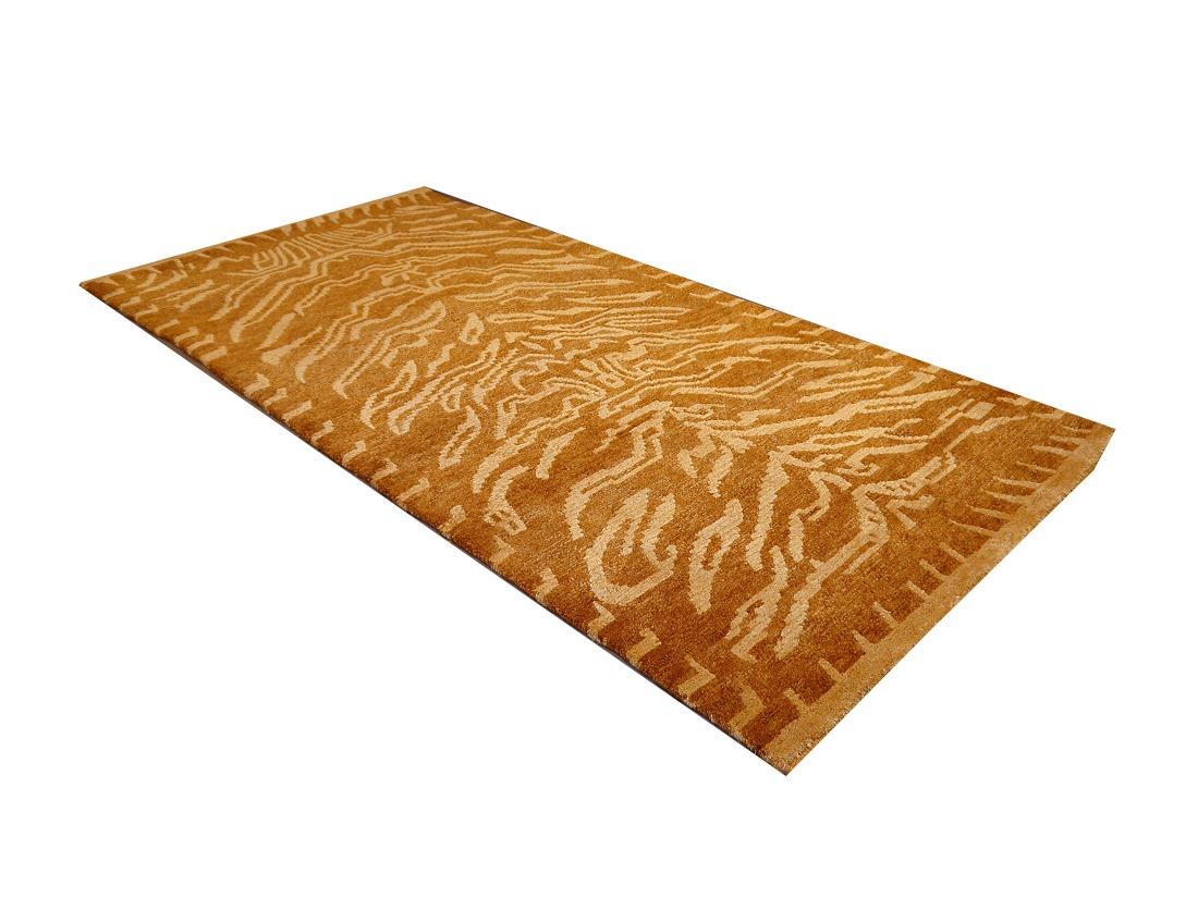 A Tibetan Tiger rug, hand knotted in Nepal, 2/3 silk and 1/3 wool pile.

This traditional Tiger rug design is typically found on antique rugs called Khaden. It describes a small sized rug of about 3 x 6 ft that was used in Tibet to decorate columns