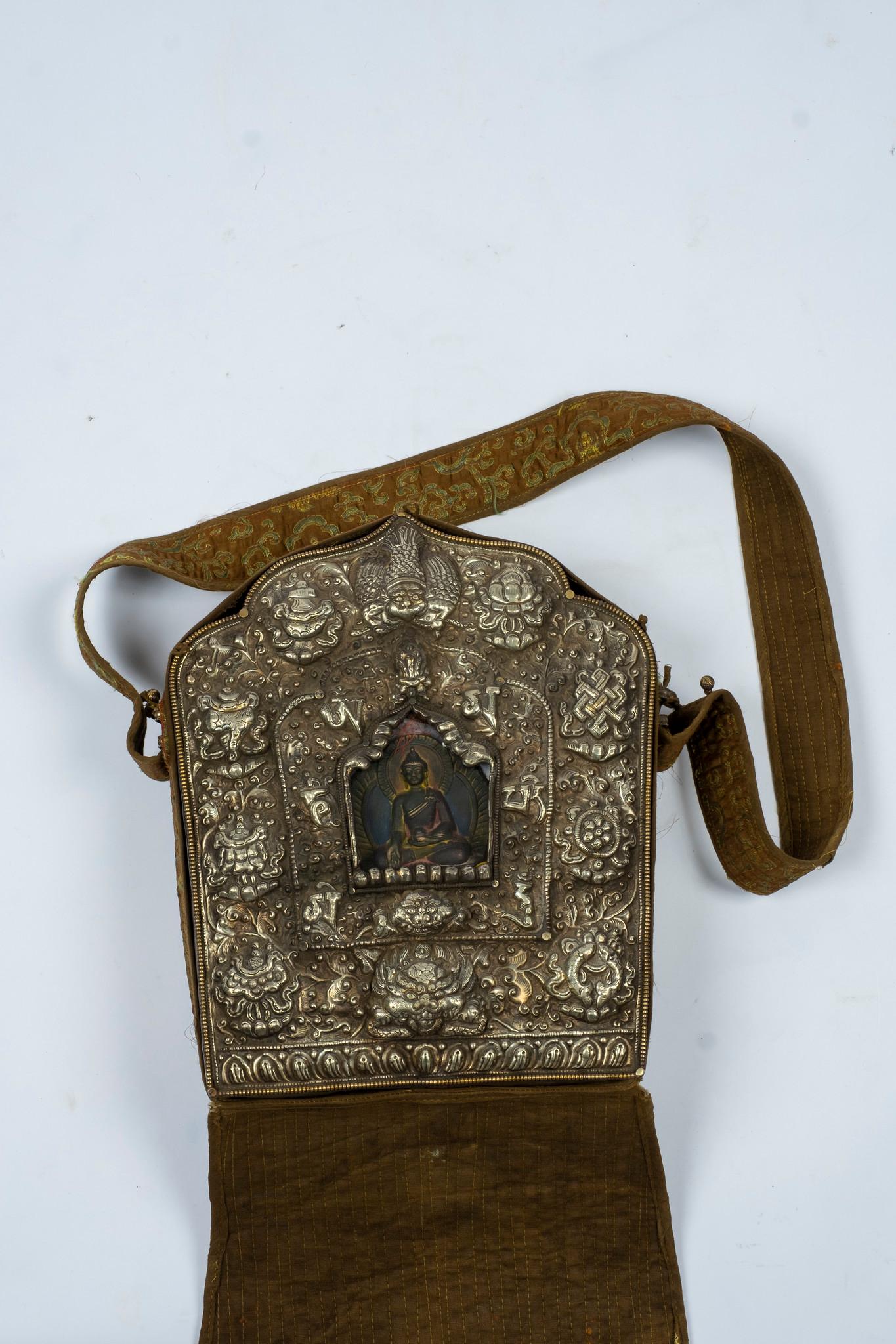 A large antique Tibetan Buddha shrine or prayer box (also known as Gau) which encases a painted terracotta Buddha figure, all wrapped in a hand embroidered quilted silk brocade. This was used as traveling shrine and carried on one's person when away