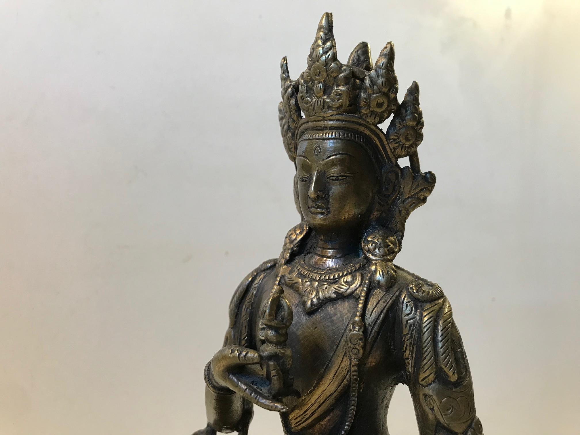 Tibetan possibly Nepalese bronze, 18th-19th century. Detailed Vajrasattva figure, a Bodhisattva. It is peacefully seated in dhyanasana (position/pose in Meditation) and resting on a single lotus base. In both hands her attributes, the Vajra symbols.