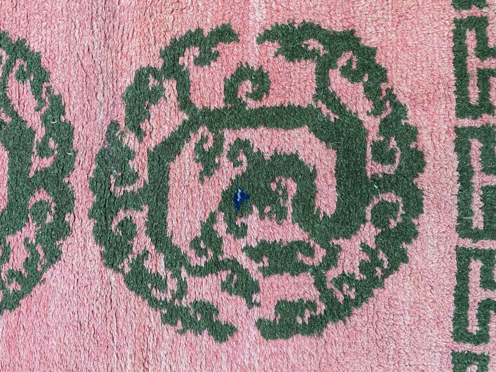 Vintage Tibetan wool Scatter rug, circa 1950, un tapis en laine noué à la main dans un motif de trois dragons, avec trois médaillons noirs comprenant des dragons enroulés sur un fond saumon. Chacun des trois dragons possède un minuscule bleu et