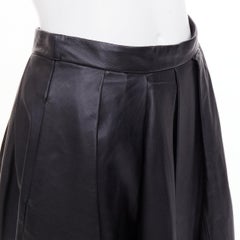 TIBI: gonna midi a trapezio con vita alta, plissettata, in pelle di agnello nera, taglia US0