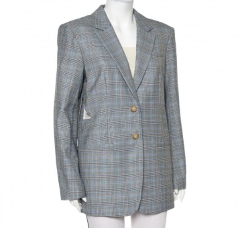 This suave Tibi blazer defines power dressing in the most effortless way. Tailored from silk and wool in a grey shade, it features a plaided design all over, notch lapels, padded shoulder for a defined appeal. The creation is adorned with cut-outs