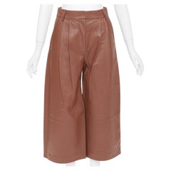 Pantaloni corti TIBI in pelle di agnello marrone rossiccio con parte anteriore a pieghe e vita alta, taglia US00