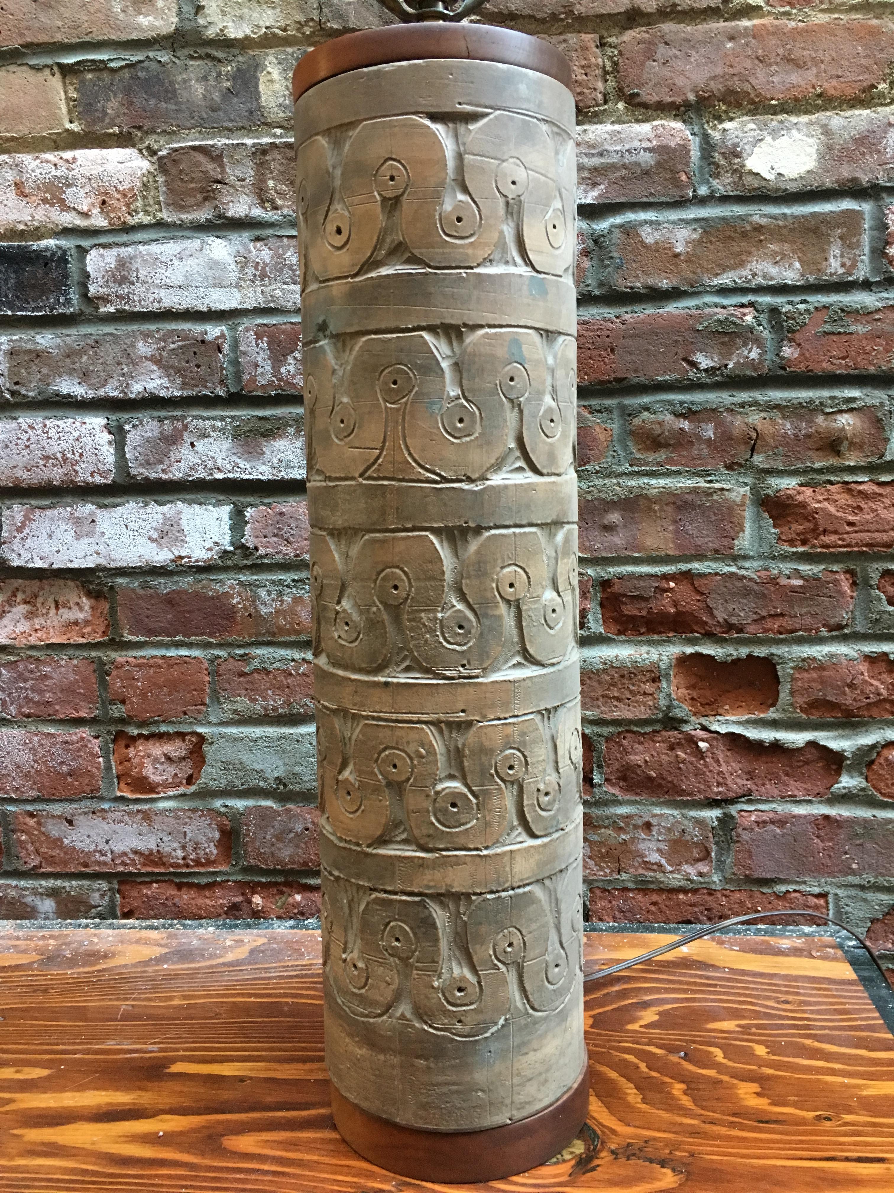Massive cylindrical Italian art pottery table lamp by TIC for Raymor, circa 1950-1960. Decorated with incised continues wave pattern with an exterior matte glaze. Signature on bottom (see photo). Base and top are capped in solid walnut. Fully
