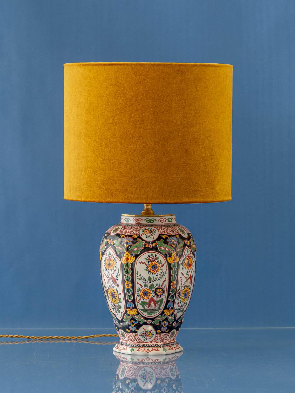 Meticulously handcrafted by Amitābha Studio in Amsterdam, Raven is a unique table lamp created from a vintage Royal Tichelaar Makkum vase, hand-painted between 1948 and 1979. This exquisite piece showcases the Delft Polychrome style with an uncommon