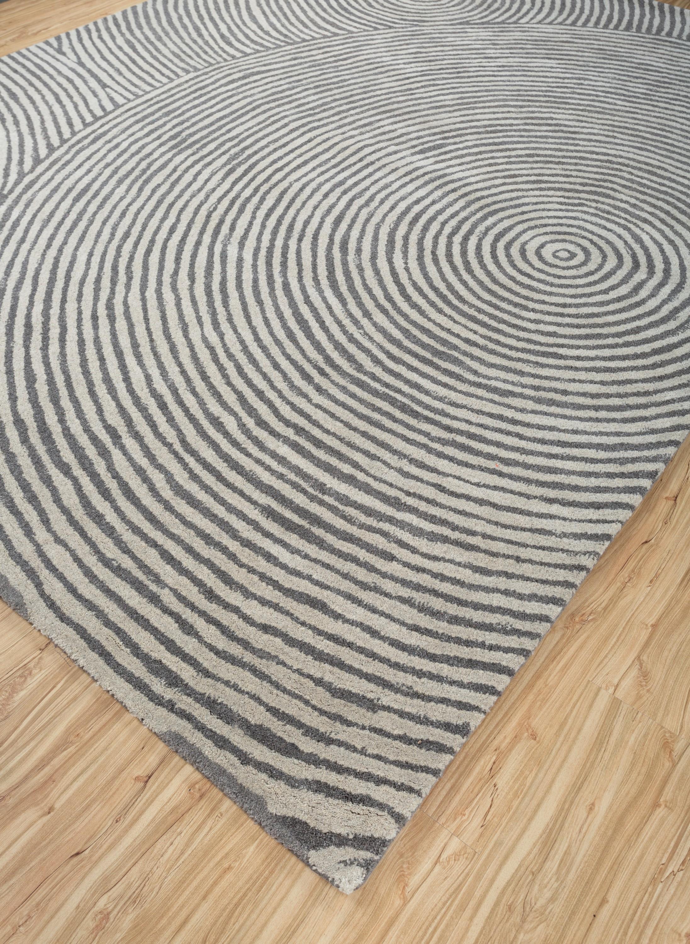 ¿Has contemplado alguna vez el corazón de una concha marina, cautivado por su forma en espiral y los secretos que encierra? Esta alfombra contemporánea, con su exquisito diseño microestructurado, encarna esa misma esencia. Hecho a mano con