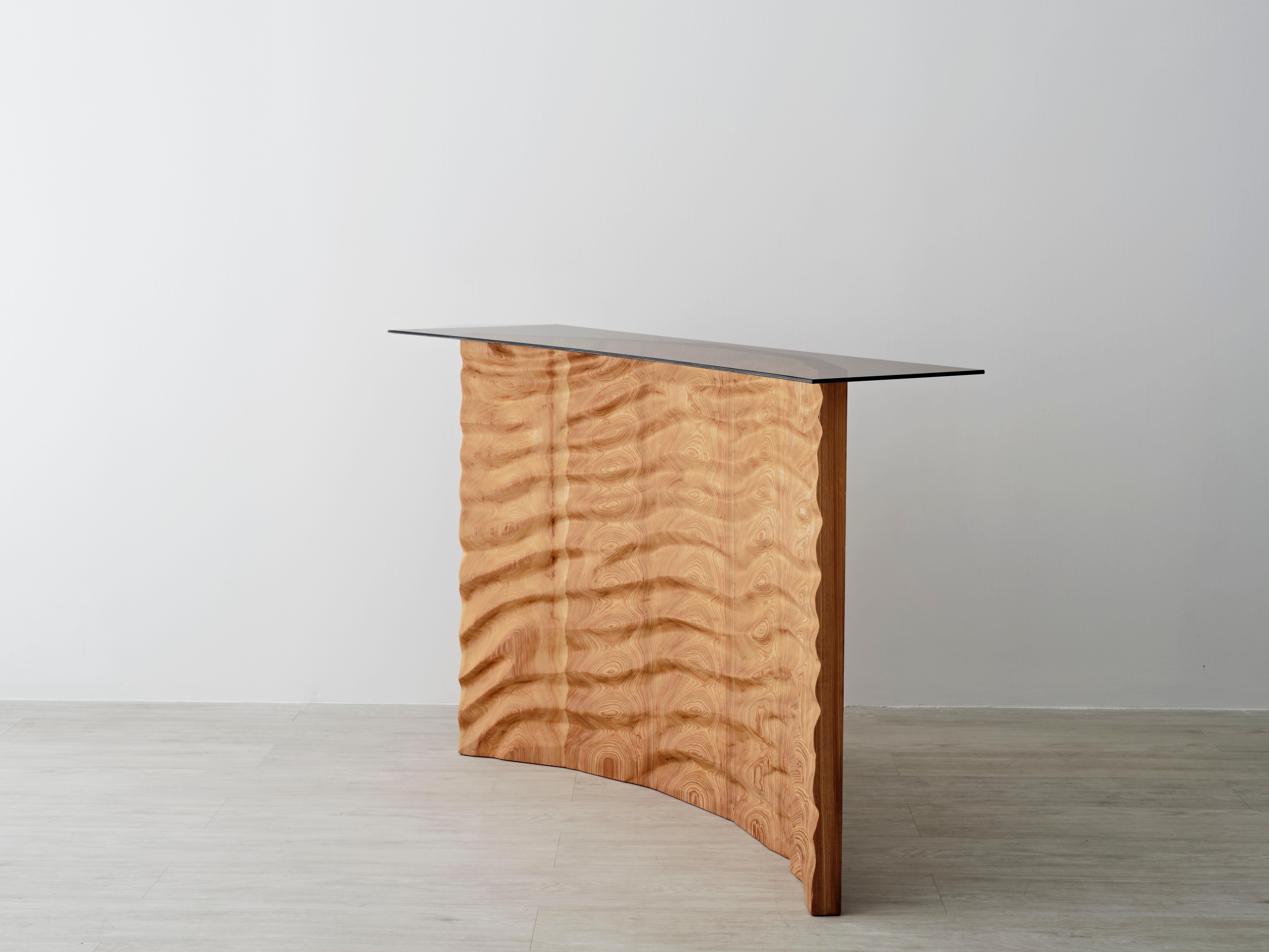 The base of the tides console is a motif hand carved in solid wood (cypress pictured). The choice to carve by hand and without the assistance of computer-guided technology renders a unique numbered piece with each commission. The motif responds to