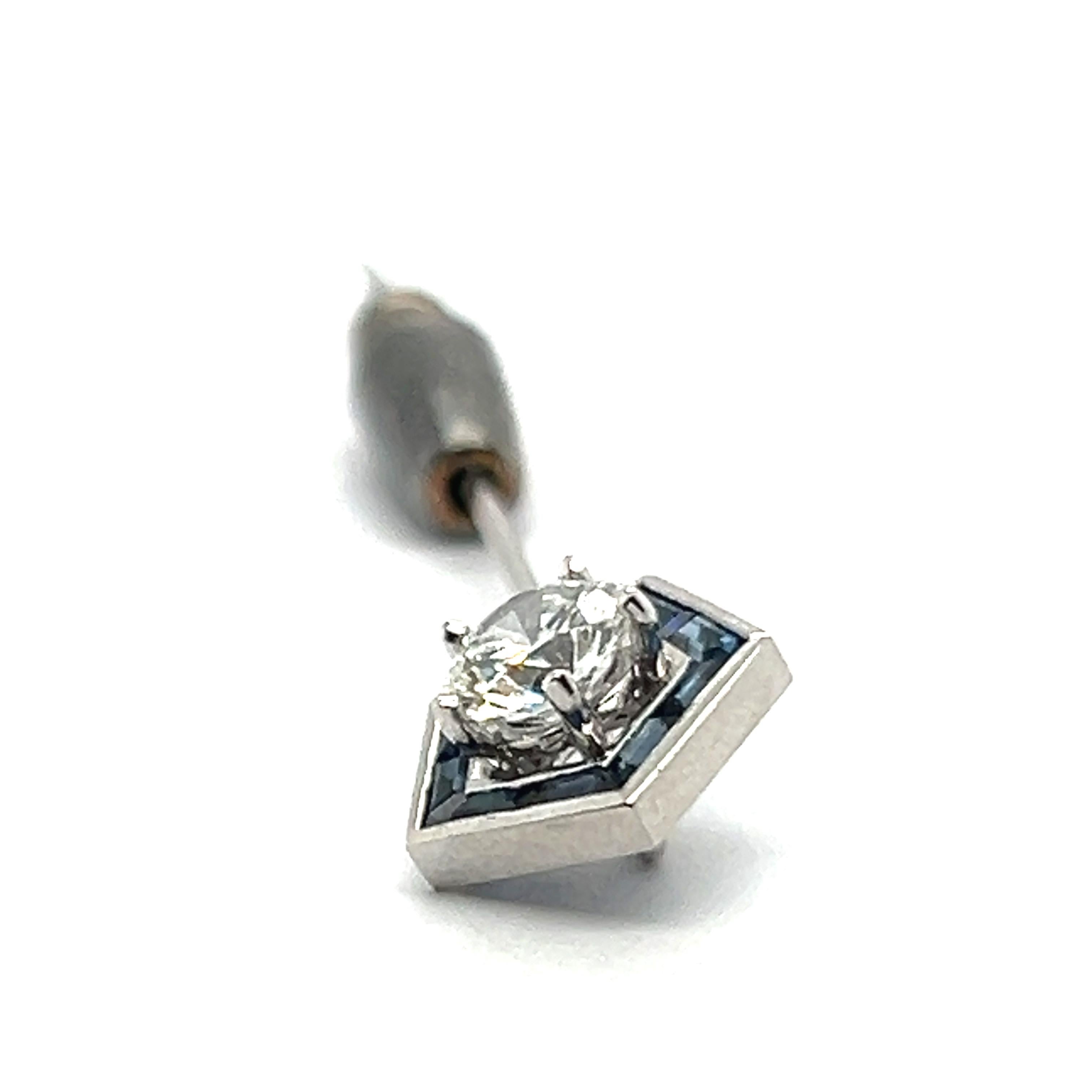 Introducing the epitome of sophistication: a tie pin brooch by the House of Gübelin. This masterpiece in 18 Karat white gold is designed in a unique pentagon shape. At its heart lies a stunning 0.80-carat, brilliant-cut diamond of F-G color and vs