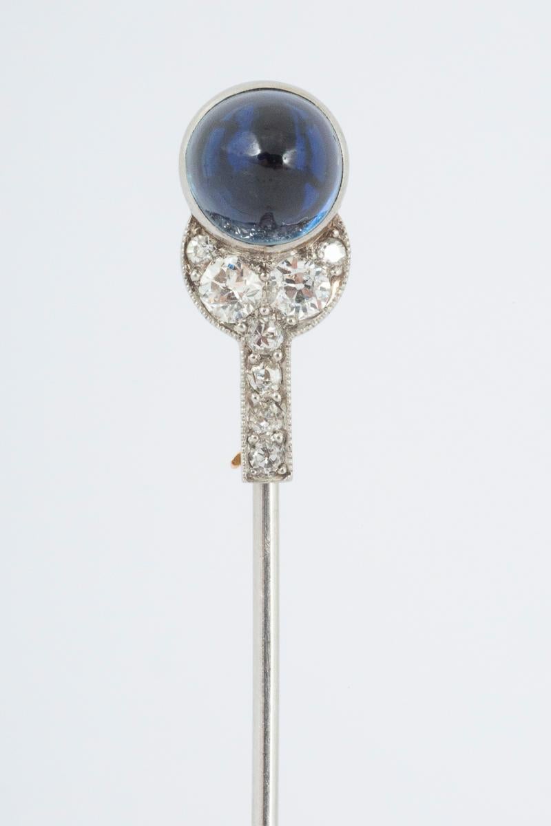 An antique platinum and 18 karat yellow gold tie pin or jabot pin made by Cartier of Paris. Set with a fine coloured cabochon cut Ceylon sapphire with a brilliant cut diamond set leaf shaped mount. The detachable point is set with a further four