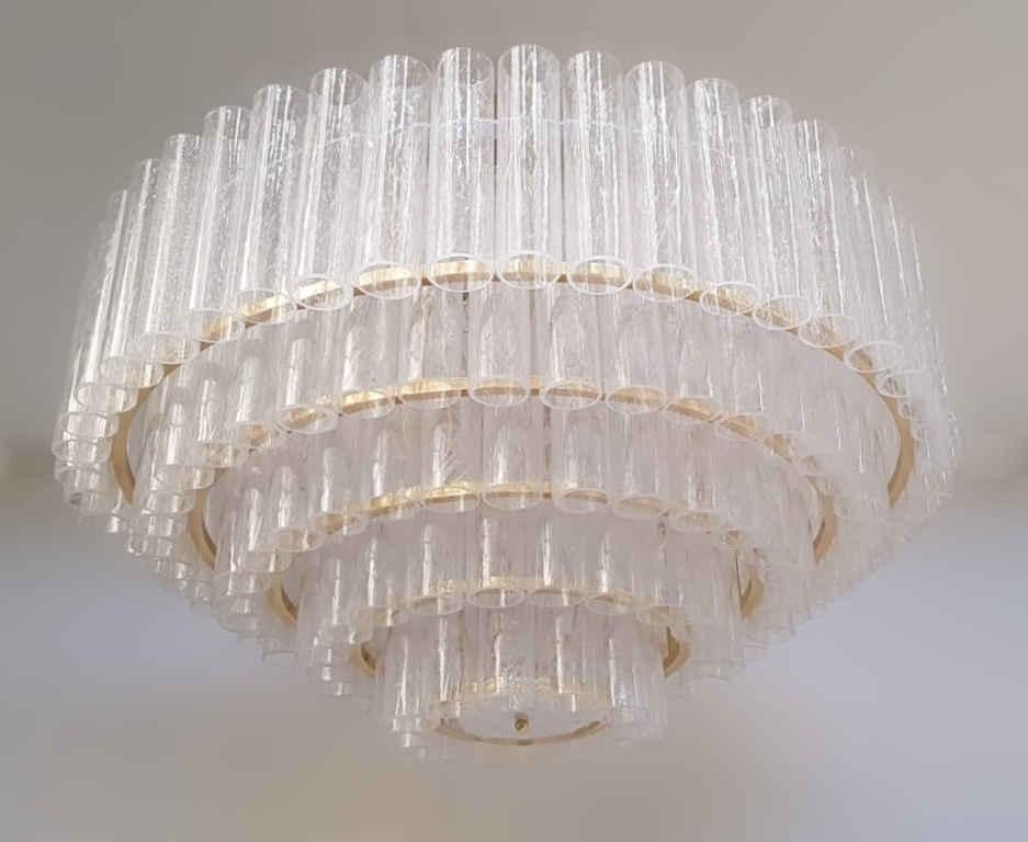 Italian chandelier with 5 tiers of clear Murano glass tubes hand blown with bubbles inside the glass using Pulegoso technique, mounted on lacquered polished brass frame, by Fabio Ltd / Made in Italy
16 lights / E26 or E27 type / max 60W