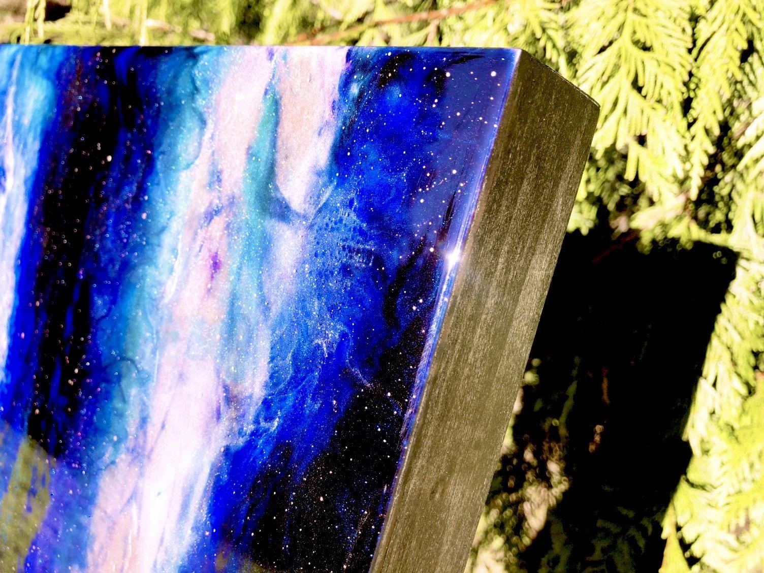 AZAE THETA NEBULA was made using Tiffani's signature holographic resin painting technique to capture the vibrant exhilaration of cosmological discovery. Rich sapphire-blue fades into the blackness of space holding tumultuously forming clouds of