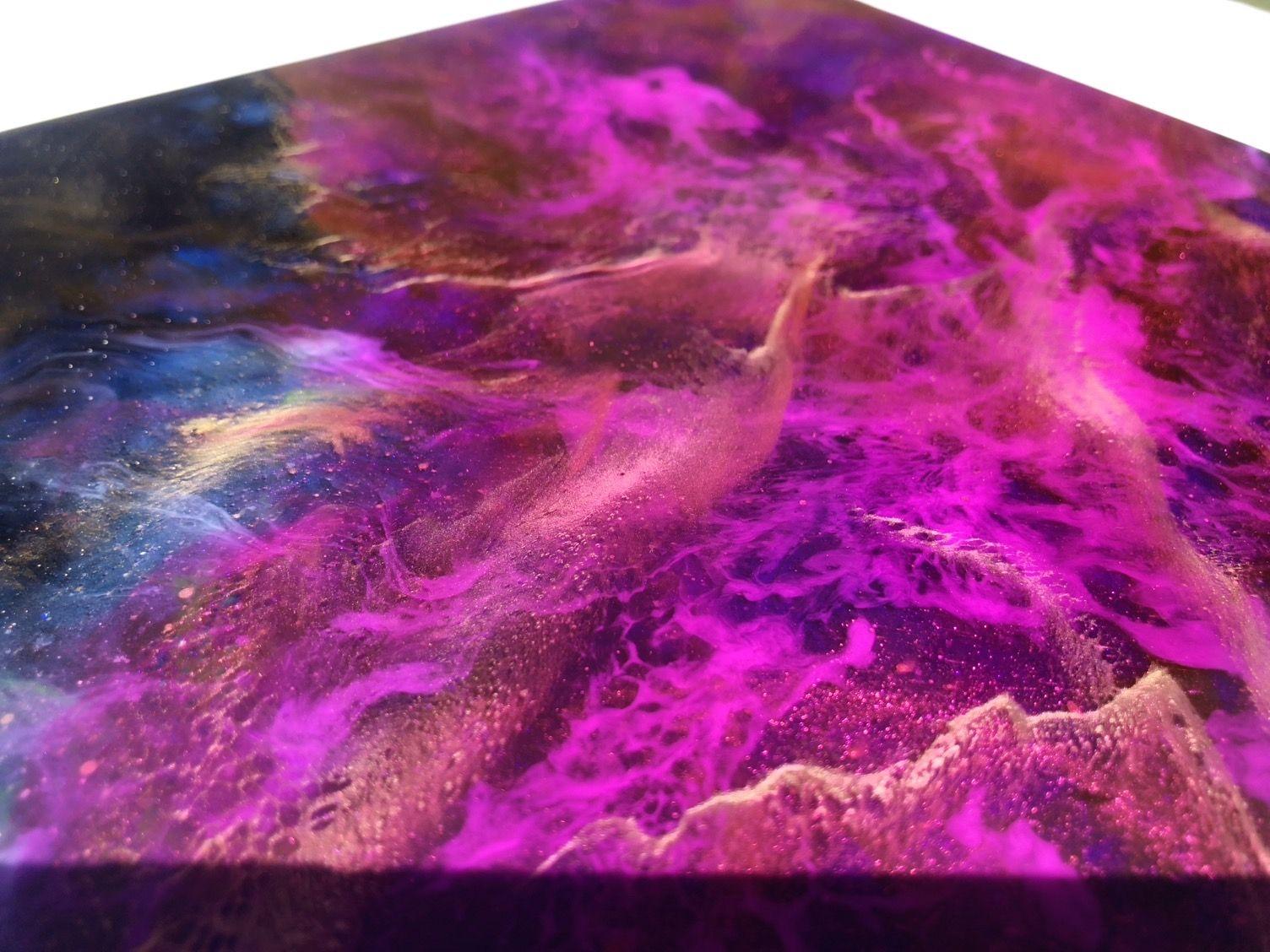 CORTIA NEBULA es una pieza cuadrada de 8x8 que Tiffani realizó utilizando su icónica técnica de pintura por capas de resina holográfica. Los atrevidos y vibrantes rosas y el radiante dorado capturan la hipnotizante sensación de otro mundo que