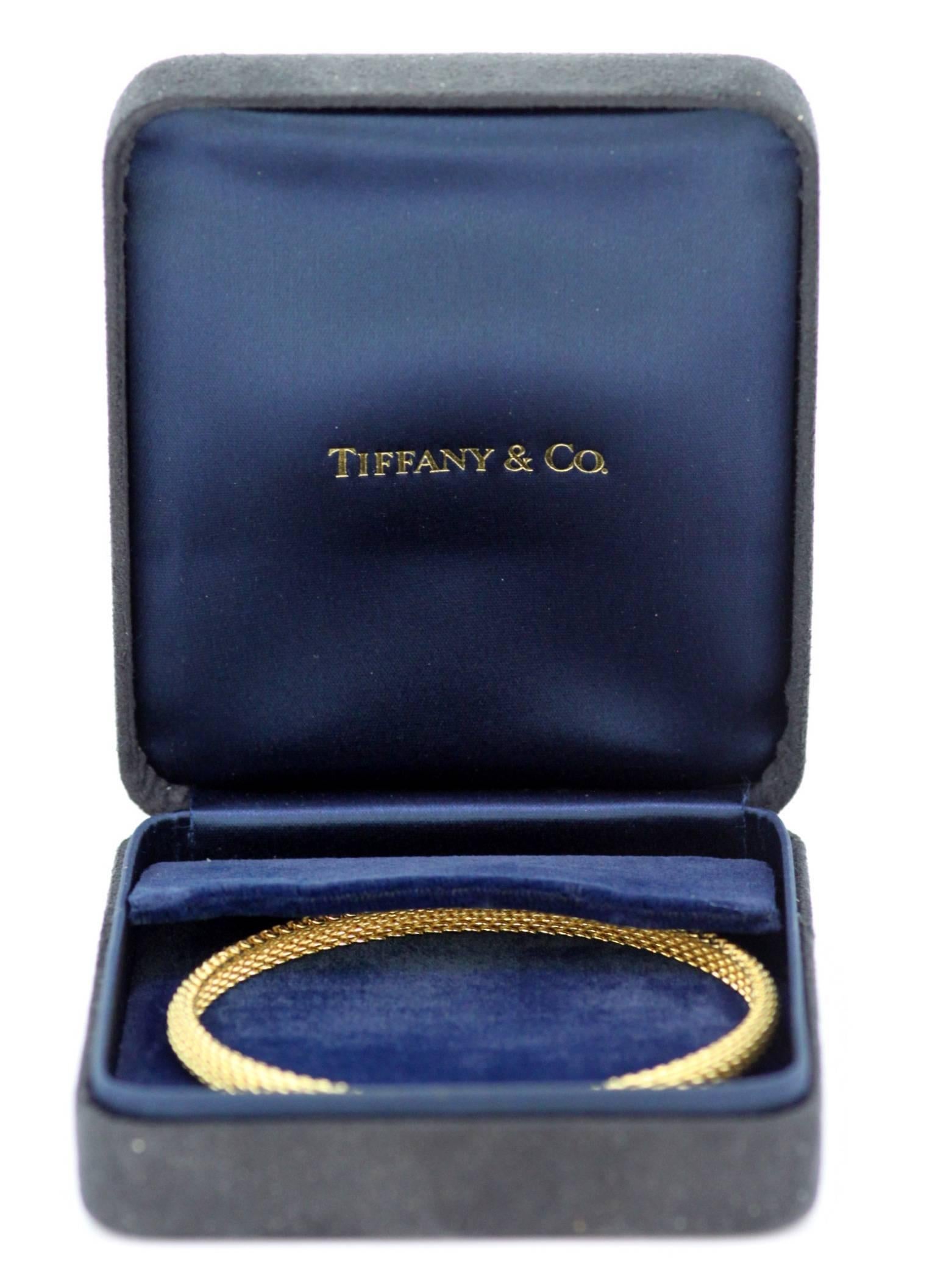 Vintage 18K Yellow Gold Ladies Bangle 
Designer : Tiffany & Co 
C.2000 
Fully hallmarked. 

Dimensions - 
Diameter x Width : 7 x 0.55 cm 
Weight : 20 grams 

Condition : Minor wear and tear, general signs of usage overall excellent and pleasant