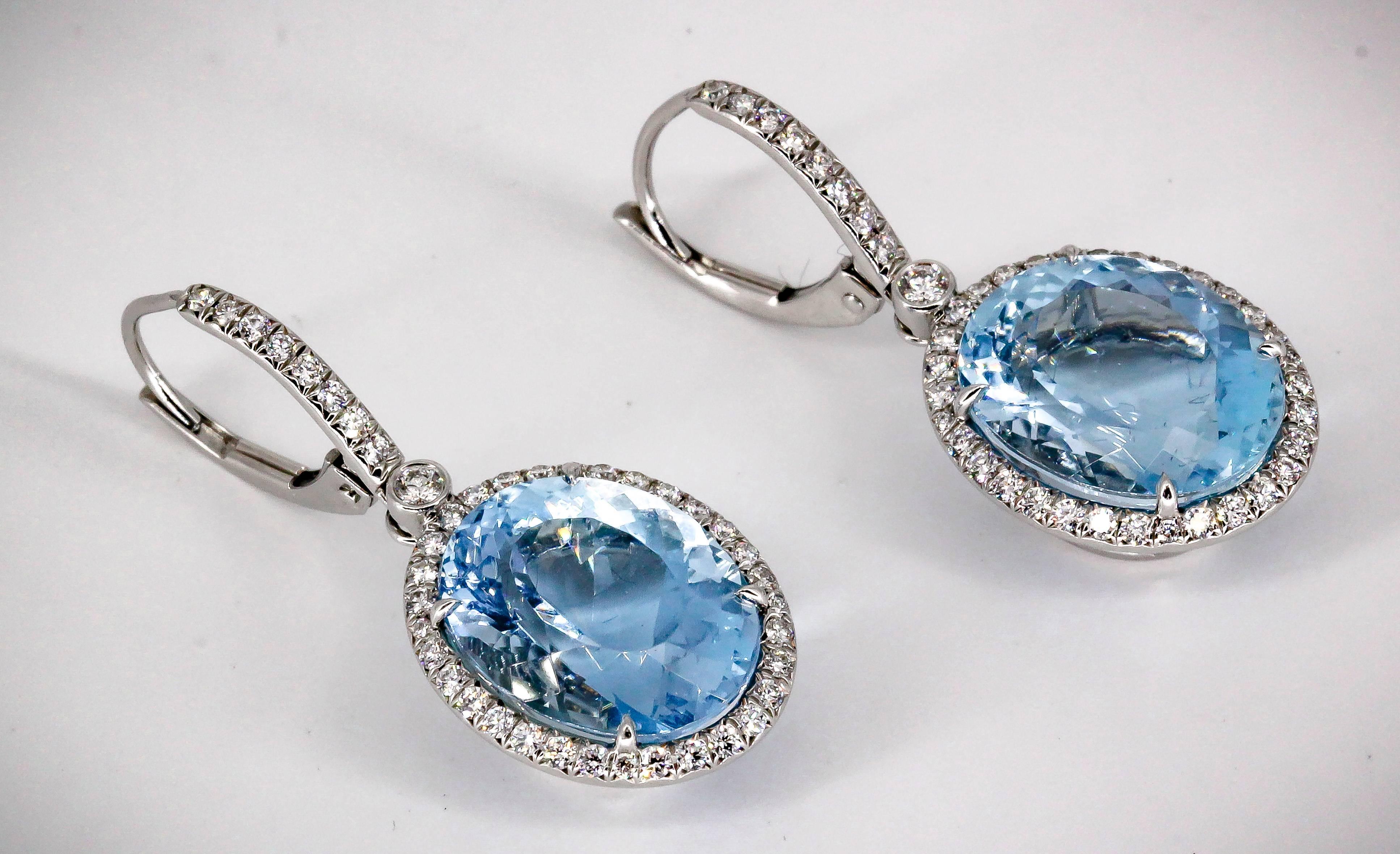 Elegant aquamarine, diamond and platinum earrings by Tiffany & Co. They feature a large aquamarine as the central stone, approx. 11-12 carats total weight, surrounded by high grade round brilliant cut diamonds over a platinum setting.

Hallmarks: