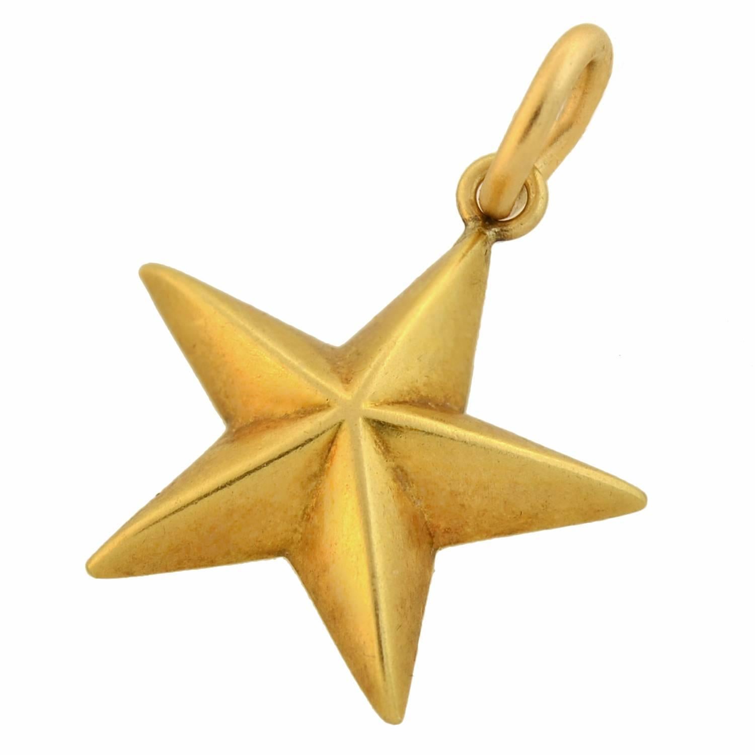 This 18kt gold star pendant by Tiffany & Co. is a stylish piece from the Art Deco era! The surface of the 5-point star has a 3-dimensional design, and is flat and smooth on the back. It hangs from a simple gold ring at the top, allowing it to hang