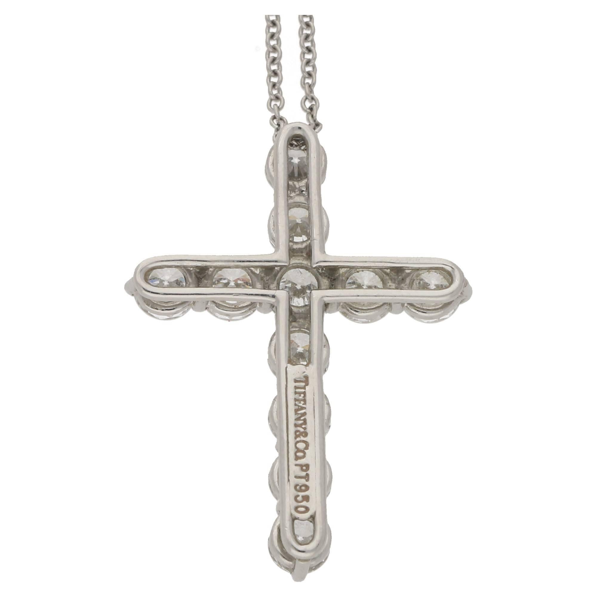 A diamond set cross signed Tiffany & Co. The cross set in platinum is formed of eleven round brilliant cut diamonds claw set to a cross setting. The cross is attached to a platinum chain also signed Tiffany & Co. Estimated total diamond weight: 1.80