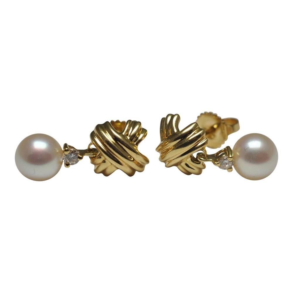 Vintage Tiffany & Co diamond and pearl earrings with their trademark gold crosses design; the earrings are in 18ct gold and formed of the gold crosses, below which, are suspended a small brilliant cut diamond and a cultured pearl giving movement to
