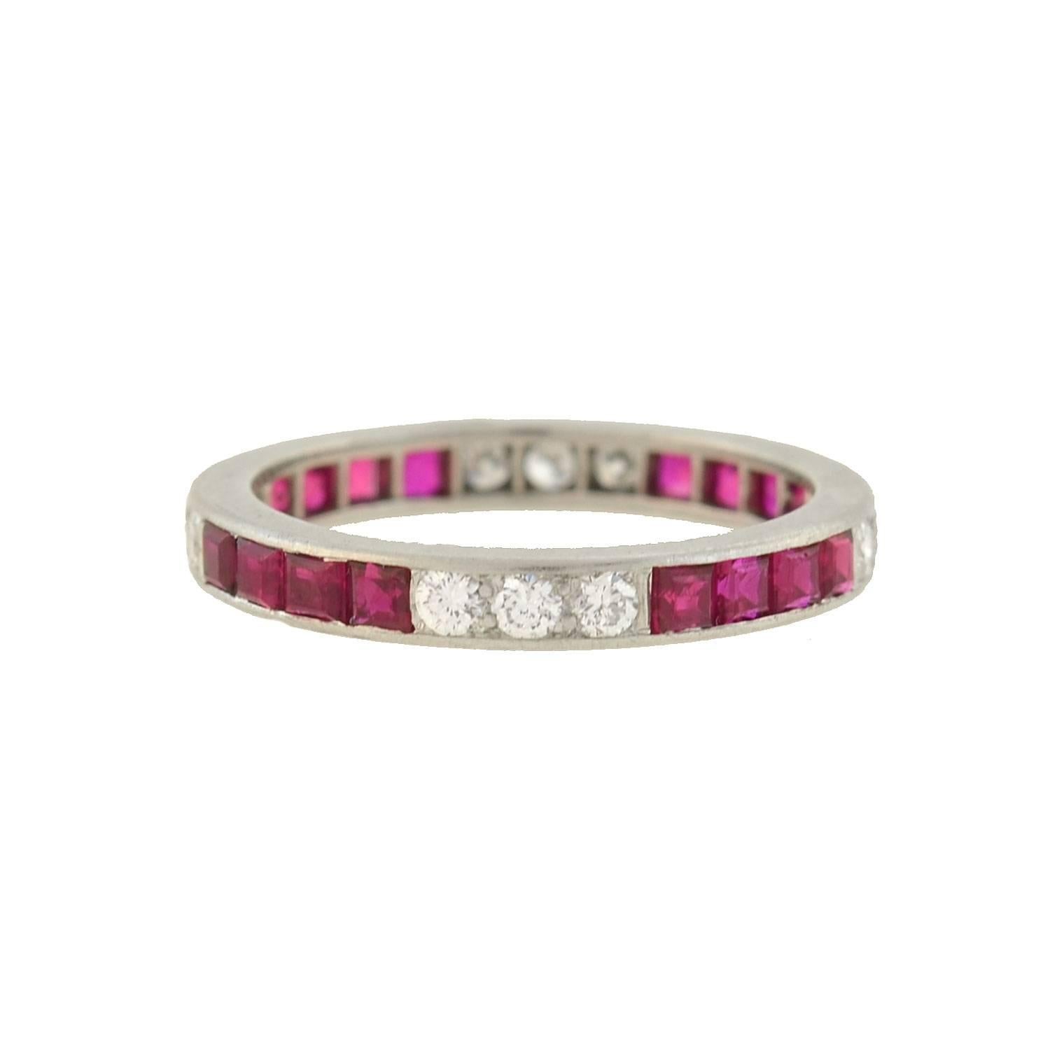 An absolutely gorgeous diamond and ruby eternity band by legendary maker Tiffany & Co. from the late Art Deco (ca1930s) era! Crafted in platinum, this feminine band is comprised of a pattern of three Round Cut diamonds and four calibrated Square Cut