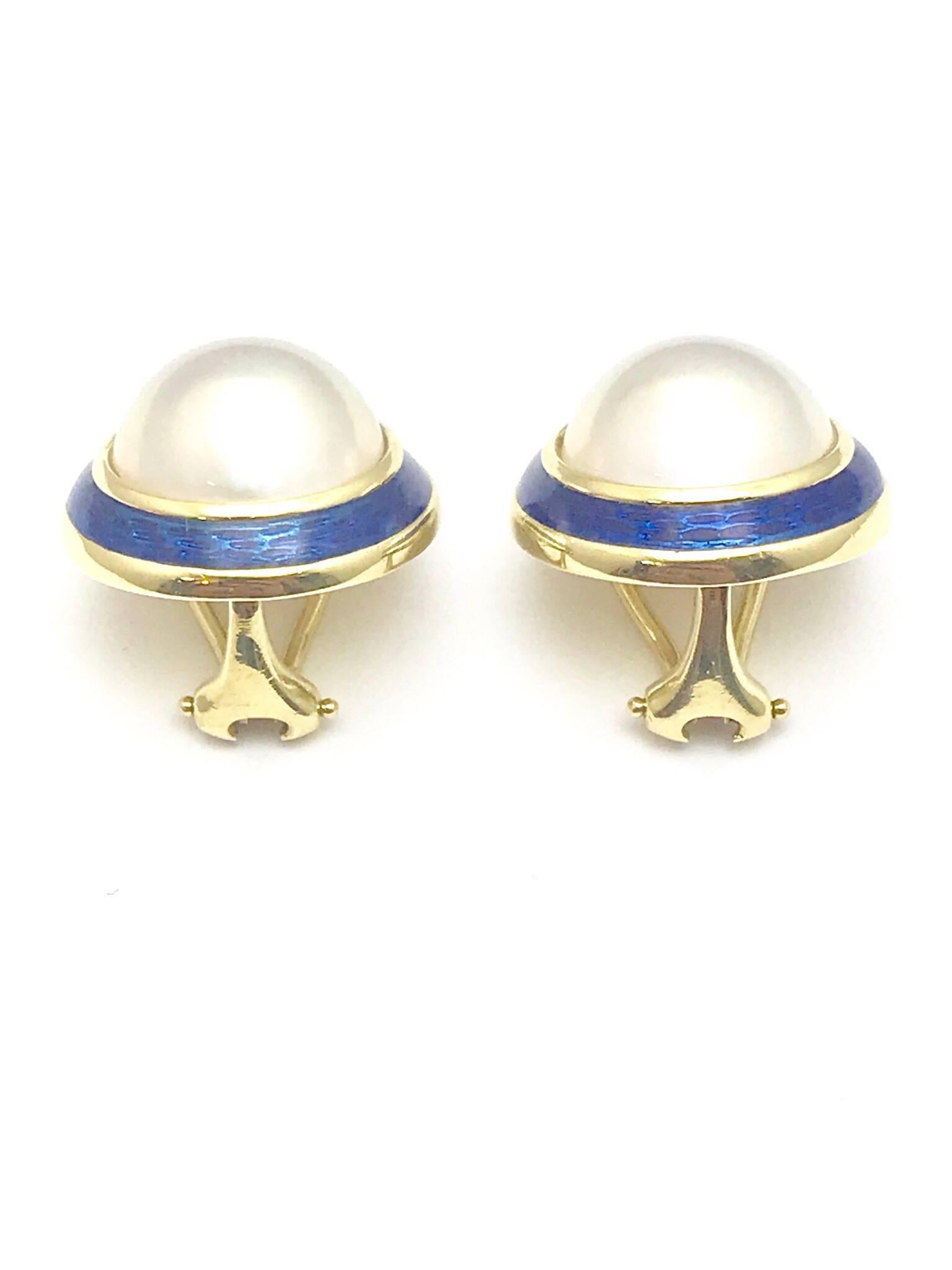 A pair of Tiffany & Co. mabe pearl and blue enamel 18 karat yellow gold clip on earrings.  The pearls measure 14.00mm, framed by a line of blue enamel, with a clip on back.  

Signature:  Tiffany & Co. 
Hallmark:  750