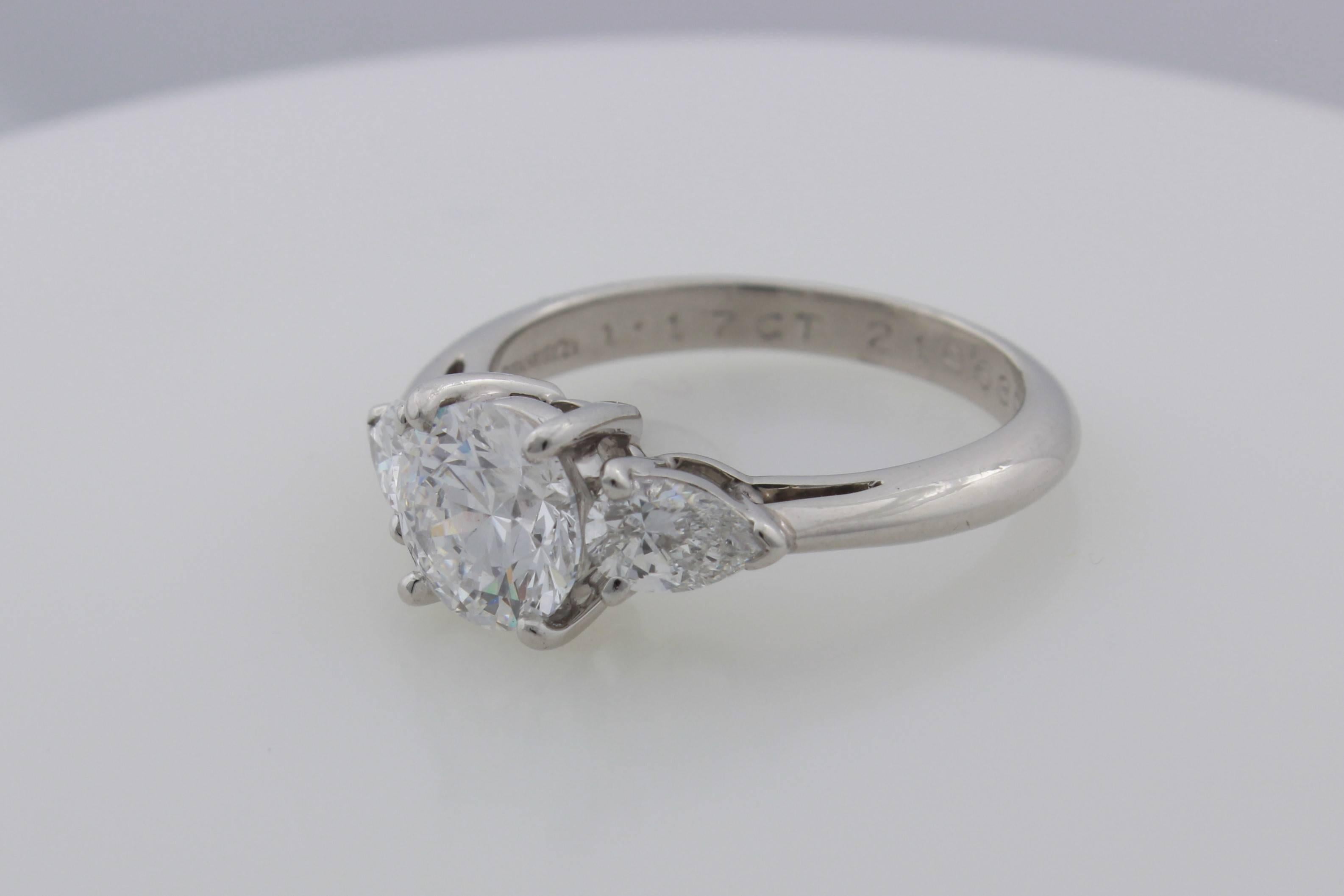 Classic Tiffany & Co. Platinum 3 Diamond Ring containing a beautifully cut 1.17 carat D VS1 round brilliant diamond set with matching pear shaped side diamonds that total .48 carats.  The finger size is 5.25 and the ring is sizeable.  Tiffany & Co.