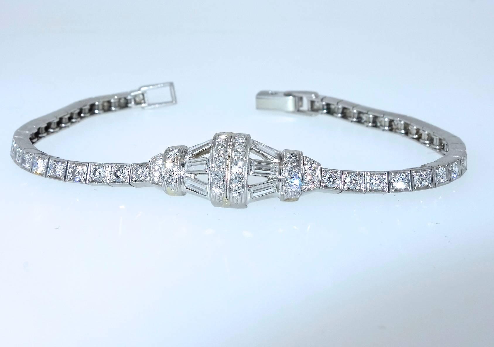 Signed Tiffany & Co. on the clasp, this platinum, petite, diamond bracelet has 6 baguette cut diamonds in the center geometric element with round brilliant cut diamonds continuing down the sides of the bracelet.  There are approximately 2.75 cts of