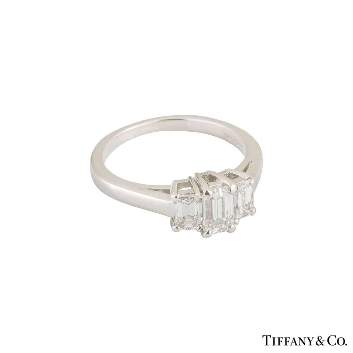 A stunning platinum Tiffany & Co. diamond trilogy ring. The ring comprises of an emerald cut diamond in a 4 claw setting with an approximate weight of 0.46ct, G colour and VS clarity. Complementing the central stone are 2 emerald cut diamonds