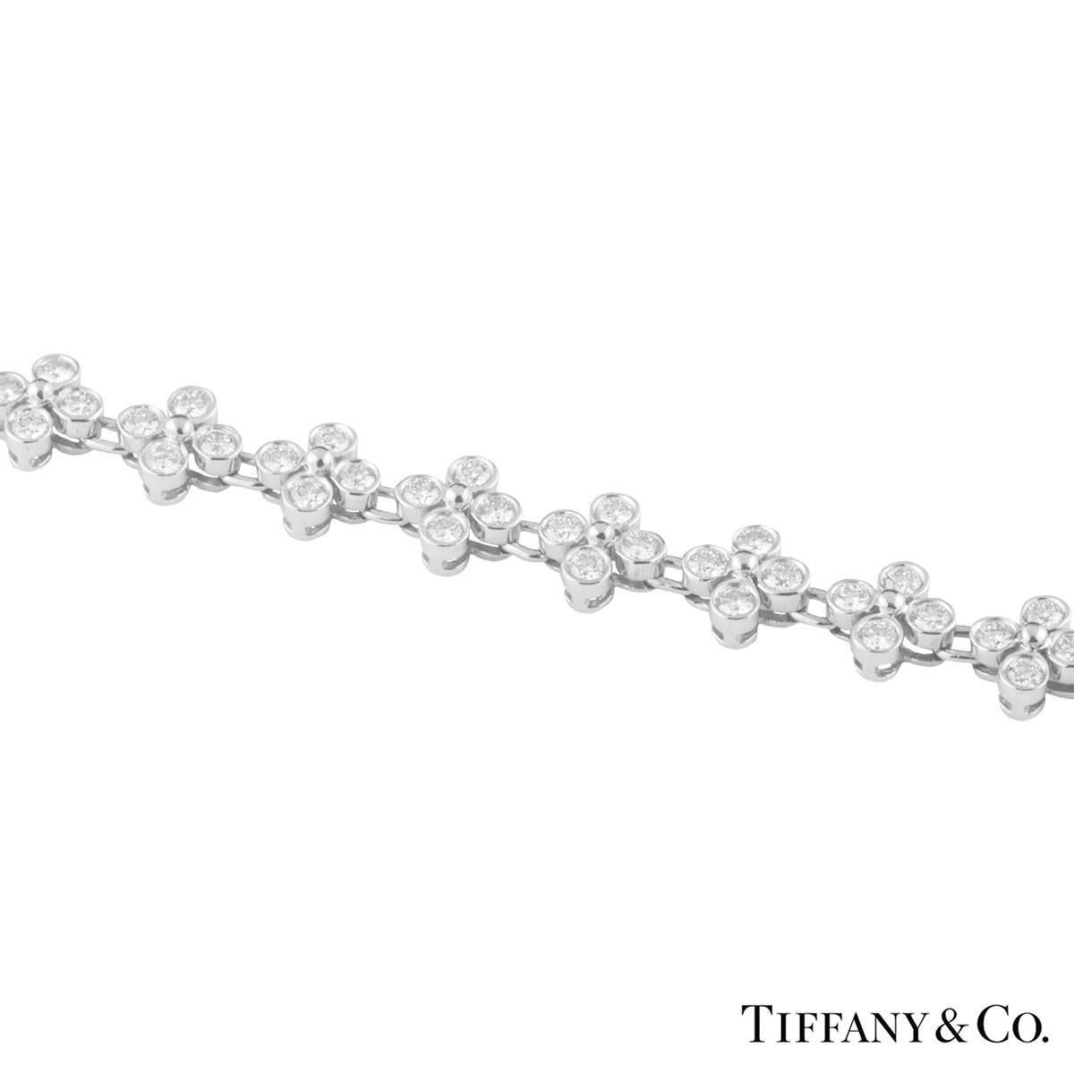 A stunning diamond bracelet in platinum from the Lace collection by Tiffany & Co. The bracelet features 27 quatrefoil flower motifs, each containing 4 round brilliant cut diamonds. The diamonds have a total carat weight of approximately 3.21ct, F+