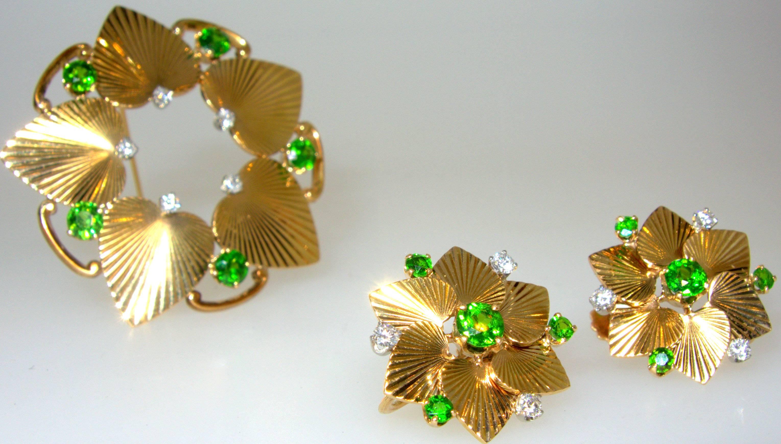 Fine bright Demantoid garnets are accented by white diamonds.  The earrings and brooch are by the famous house of Tiffany & Co.  Retro in design with heart shaped motifs accented with  highly unusual green garnets.