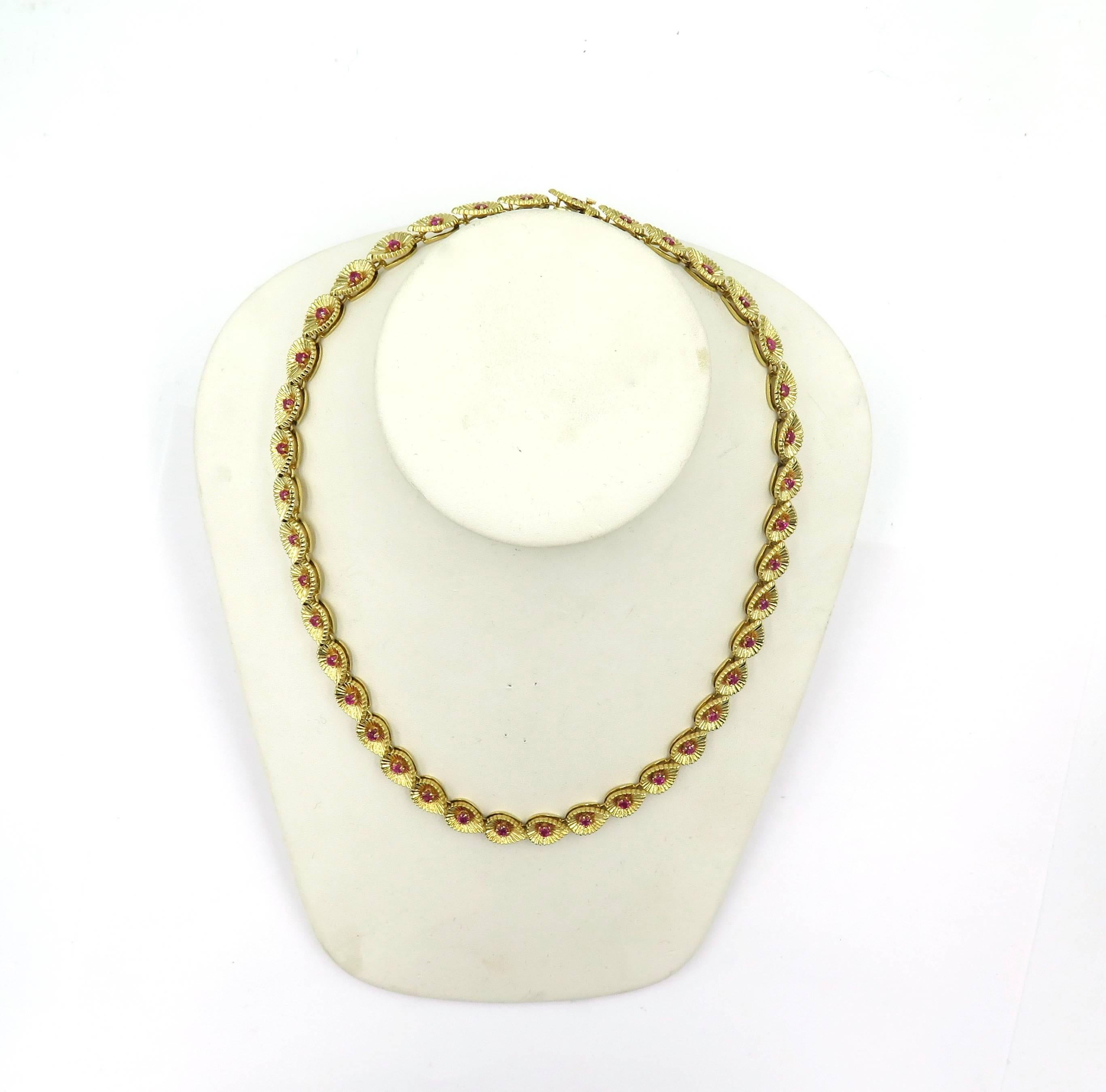 A 14 karat yellow gold and ruby necklace. Tiffany & Co. Circa 1950. Designed as a series of drop shaped fluted gold links, each centering a circular cut ruby. Length is approximately 18 inches, gross weight is approximately 63.3 grams. numbered #943.