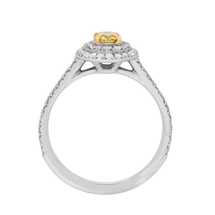 This stunning Tiffany & Co ring is a wonderful example of a double halo ring with a yellow fancy diamond centre stone. The centre stone has a weight of 0.24 carat and is accompanied by diamonds in the shoulders and halo, which have a total weight of