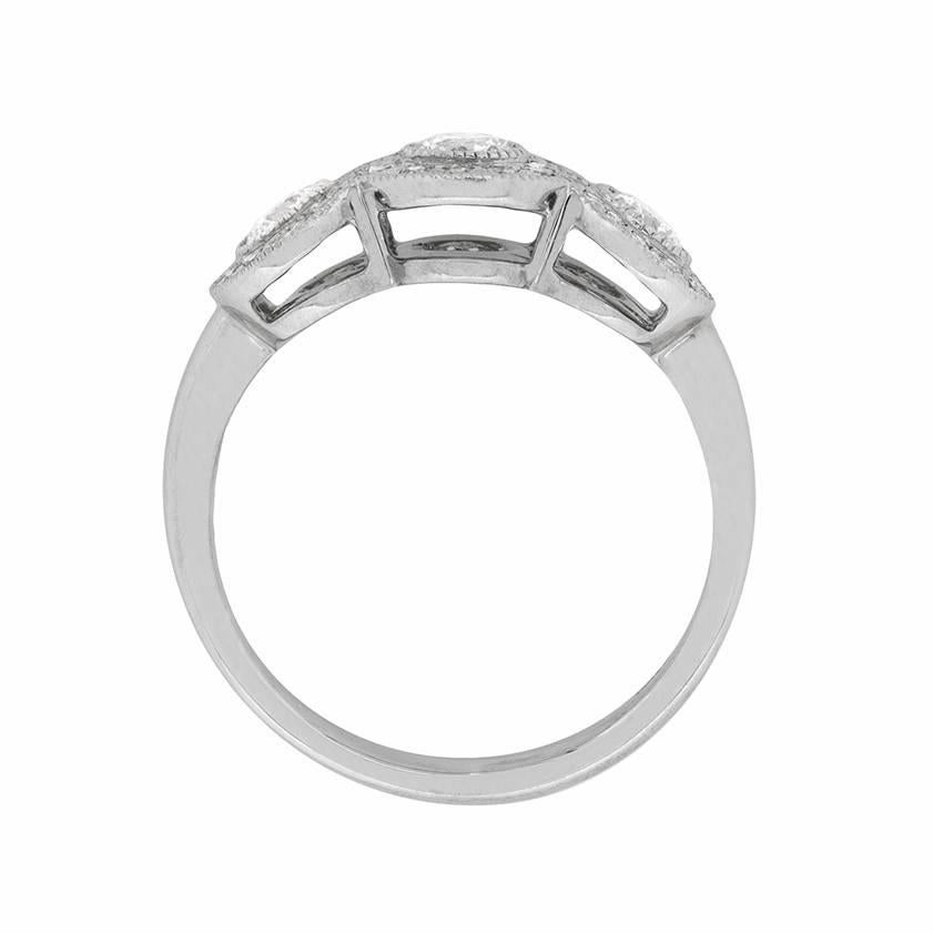 This elegant three stone ring is from Tiffany & Co. It is a unique and stunning design, featuring a total weight of 0.55 carat. The round brilliant diamonds are F in colour and VVS in clarity, and they truly dazzle. They are grain set within