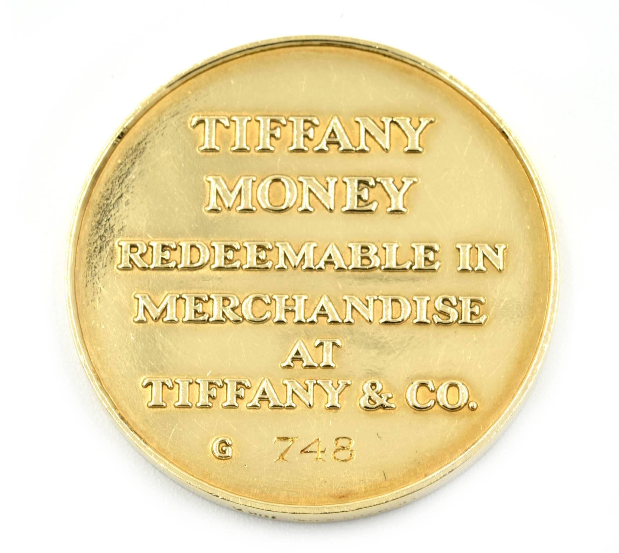 Designer: Tiffany & Co
Collection: Tiffany Money
Material: 18k yellow gold
Dimensions: coin measures 1 ¼ inches long and 1/8 inches wide
Weight: 32.95 grams
