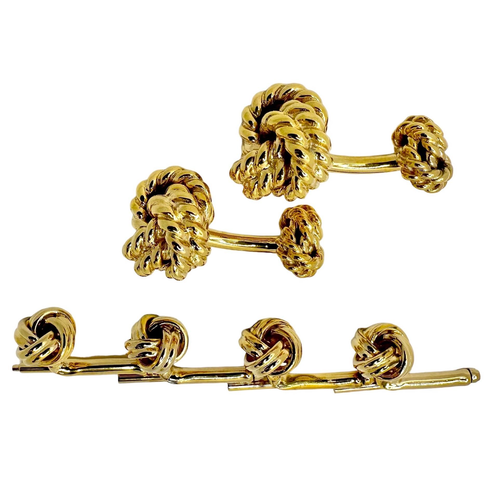 This pair of truly iconic 14k gold Tiffany knot motif cuff links with four matching 14k gold stud buttons by a different maker, creates a wonderful dress set. The The cuff links measure 11/16 inches in diameter and the stud buttons measure a