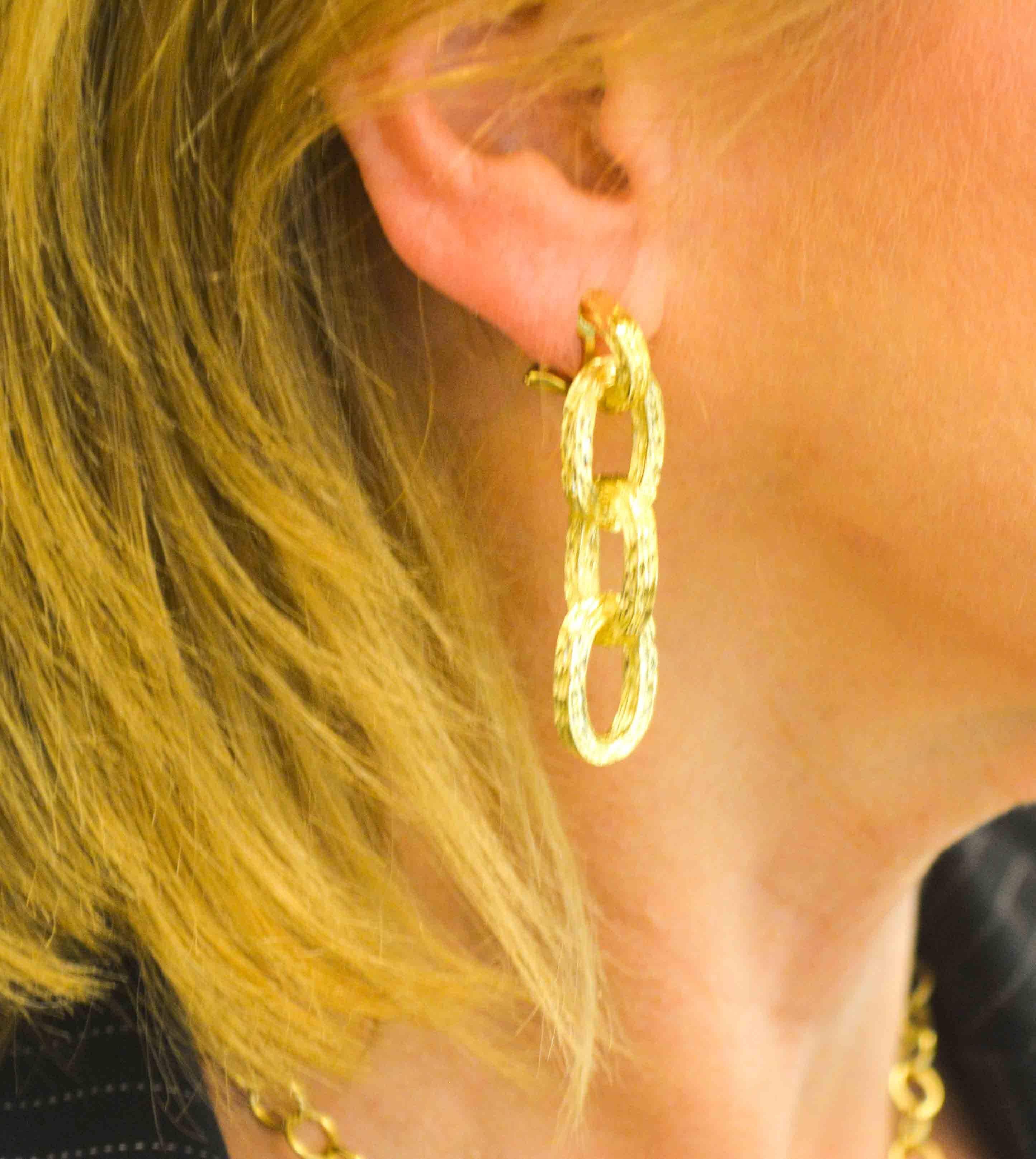 Subtly understated and extraordinarily sophisticated are these Tiffany & Co. 18 karat etched yellow gold hoop earrings. These clip-on earrings have three dangling oval hoops with intricate hand engraving ready to catch the light.  Expertly crafted