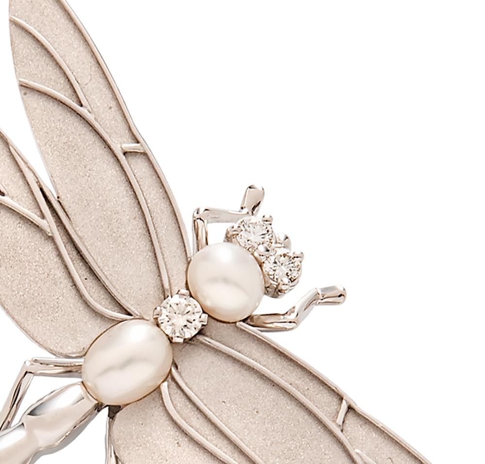 This beautifully rendered vintage dragonfly brooch fully illustrates the graceful art of Tiffany jewelry.  A diamond and two pearls form the body and two diamonds are set for the eyes. The wings are a matte brushed gold, while the remainder of the